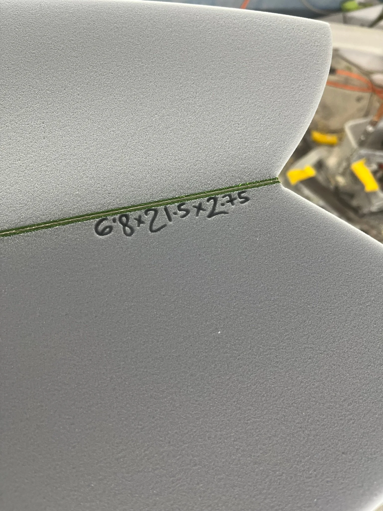 Close-up of a grey surface with a green line and black numbers '68+15x2=5' written along it.