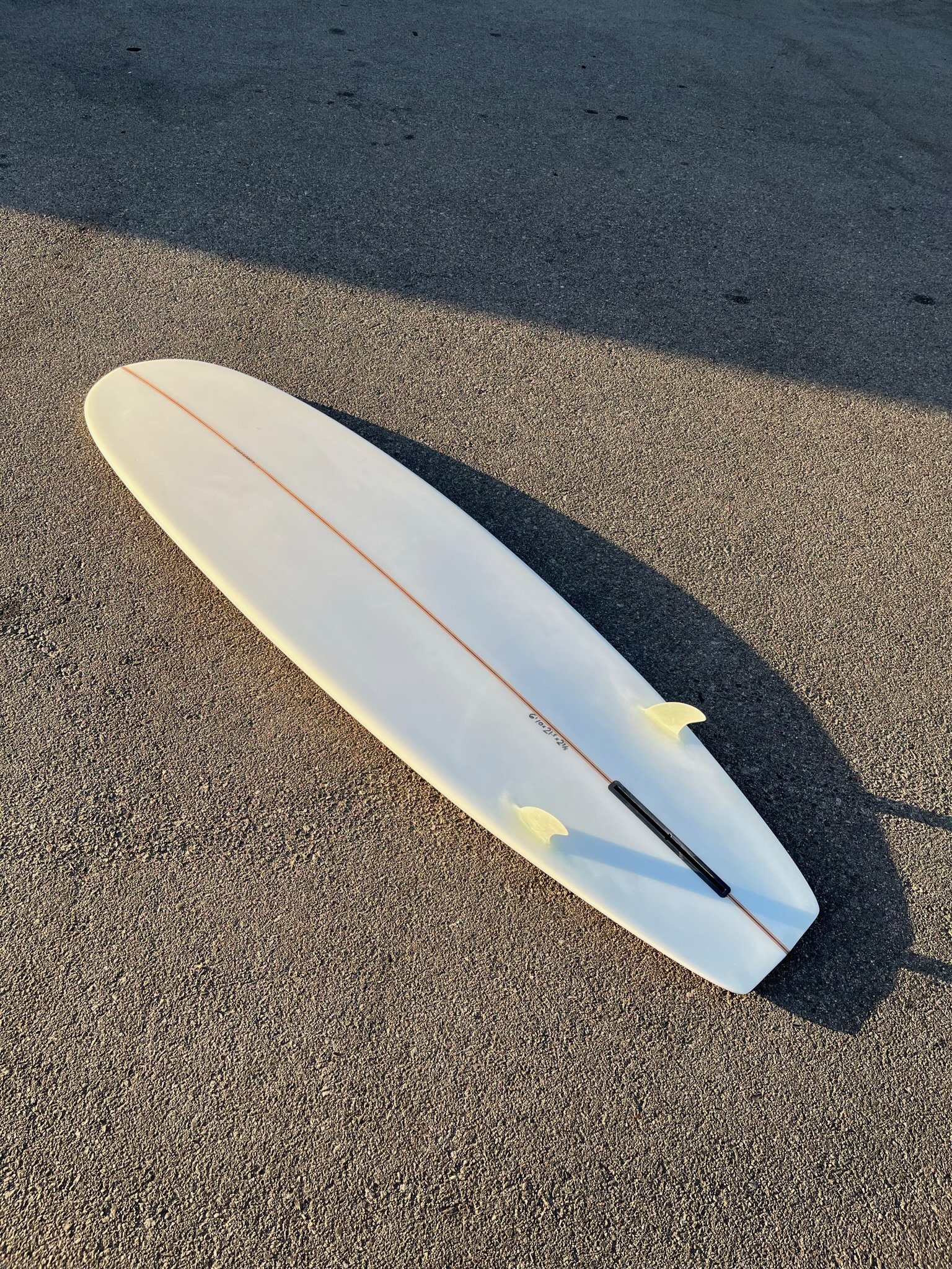 Surfboard on sandy ground with shadow