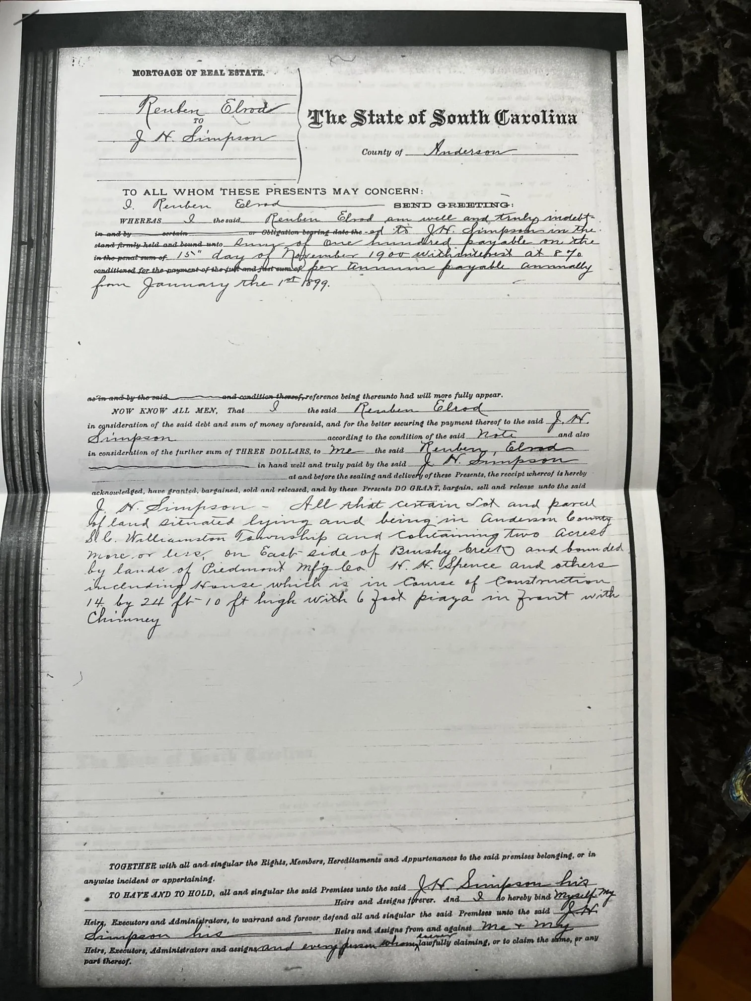 A scanned historical land deed document from South Carolina, signed and handwritten, with some text and signatures visible, laid on top of a dark marble surface.
