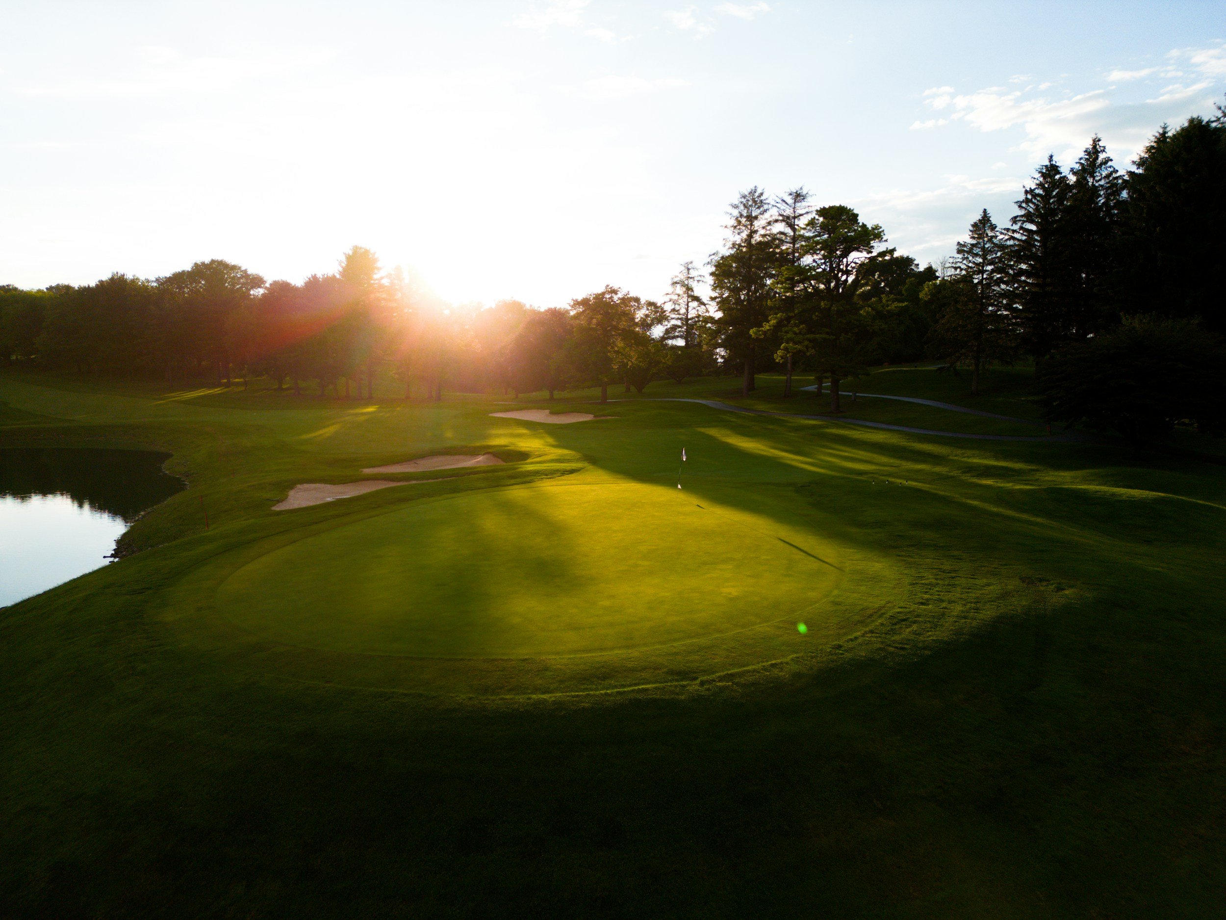 Sunrise over a quiet golf course green with no people, used as Deadhead Golf homepage setting.