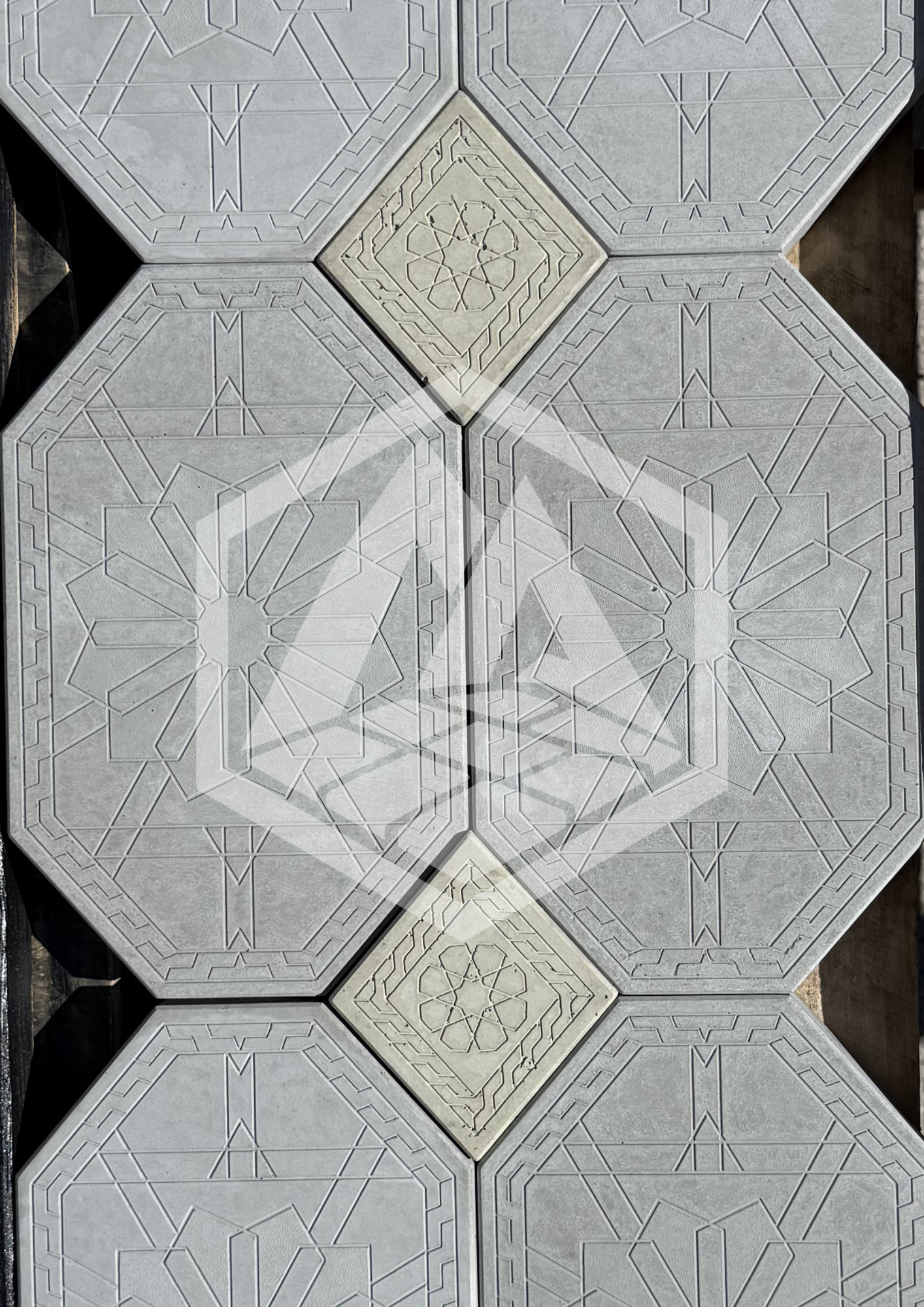 A covered outdoor walkway with large decorative, patterned tiles. The tiles feature geometric designs and are arranged in a repeated pattern.