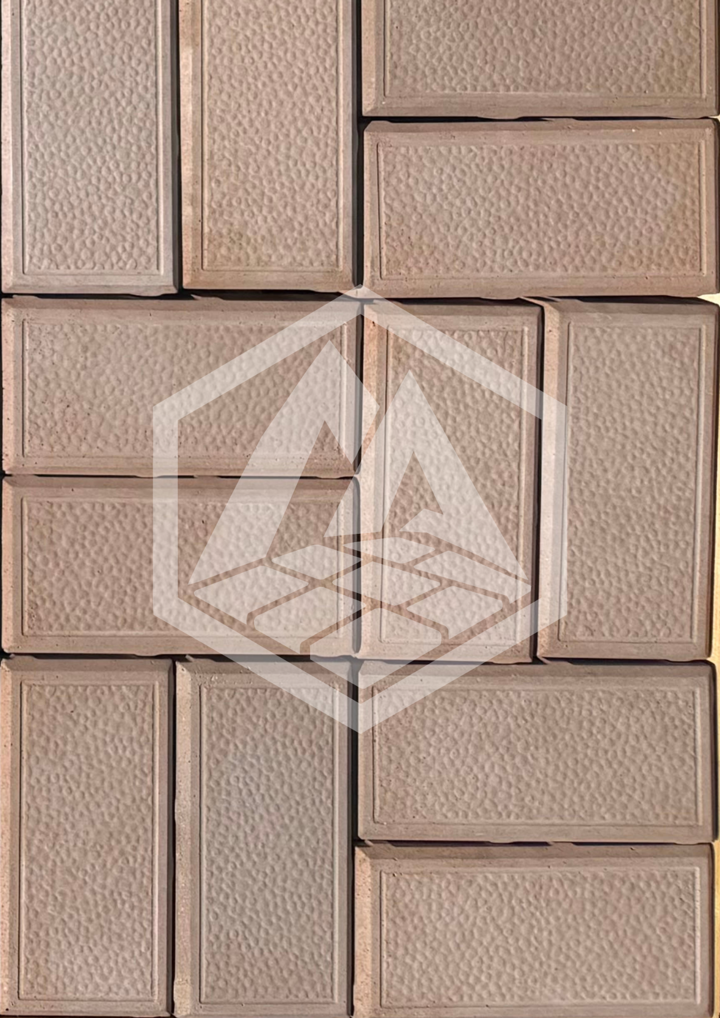 A close-up photo of a wall with beige bricks that have a textured surface. The bricks are arranged in a horizontal pattern with visible mortar lines.