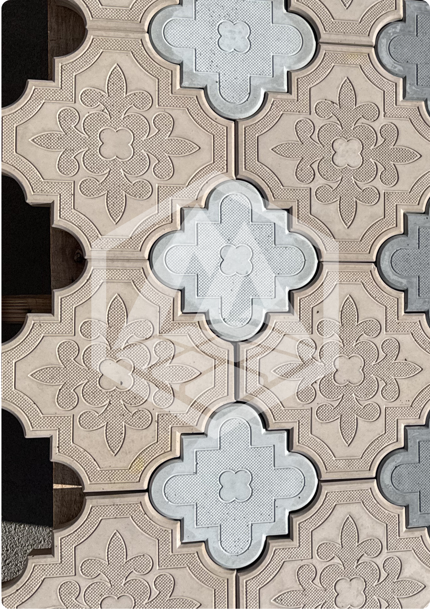 Close-up view of ornately patterned decorative tiles with intricate floral and geometric designs in shades of beige, white, and light gray.