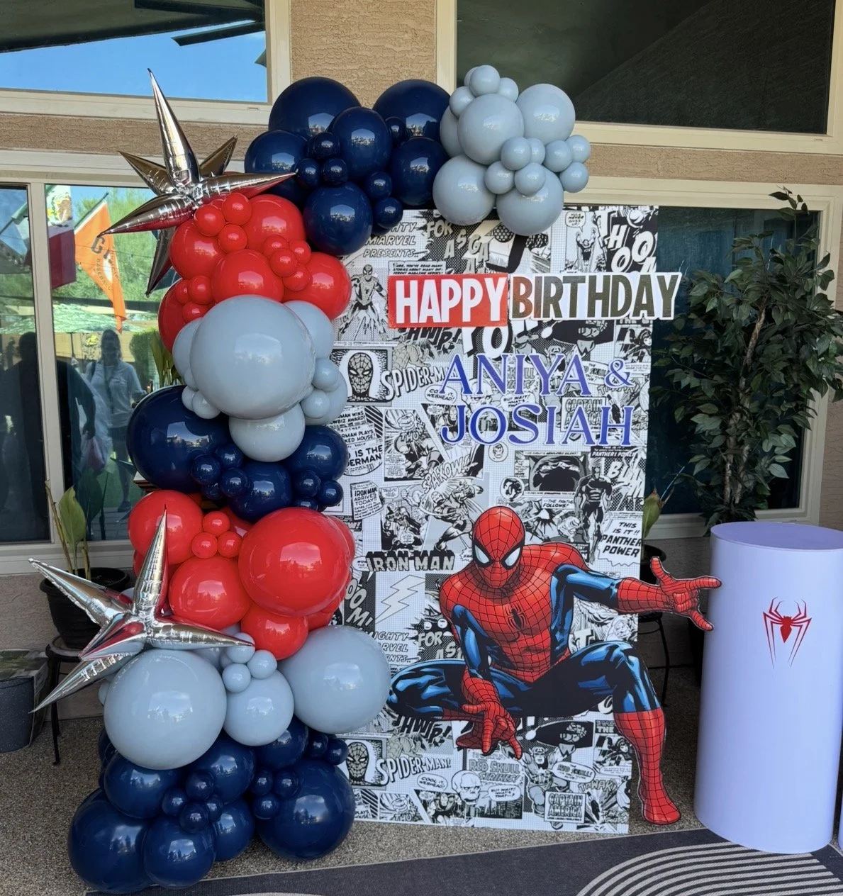SpiderMan birthday setup with custom comic backdrop and SpiderMan prop
