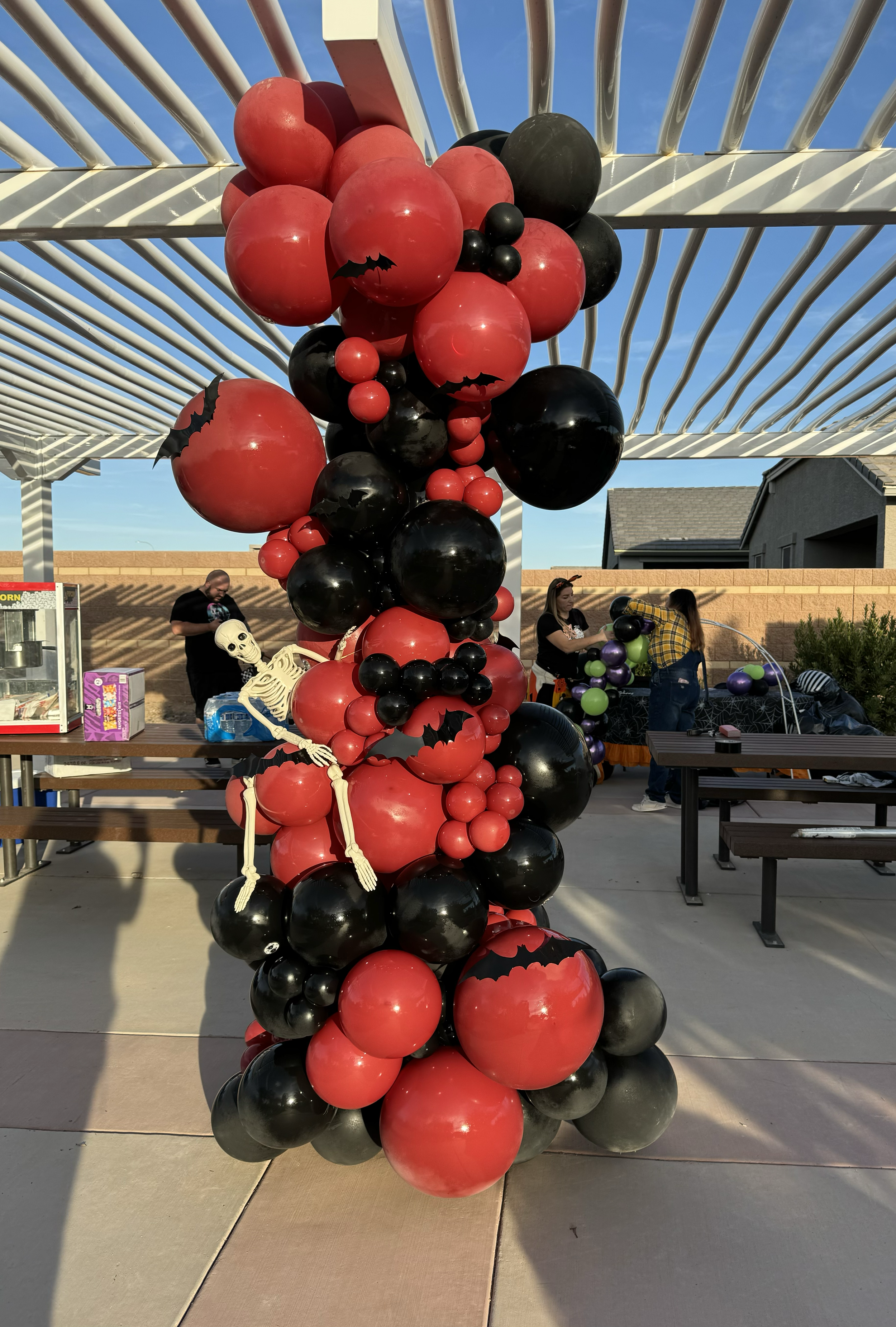 A Halloween-themed balloon garland with spooky bats & skeleton accents
