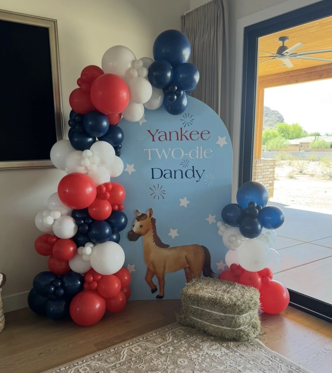 'Yankee TWO-dle Dandy' custom backdrop surrounded by red, white, and navy blue balloons. 