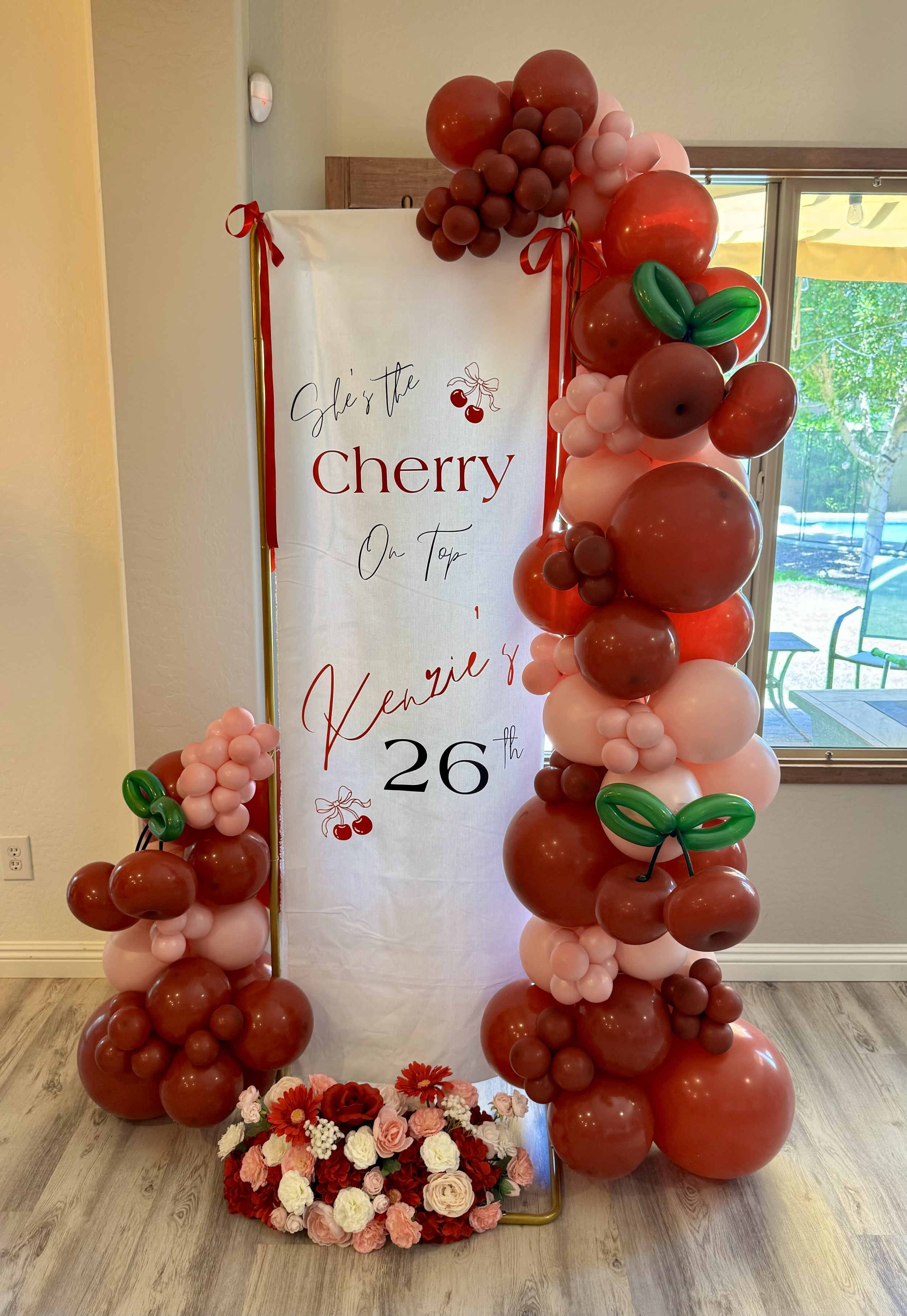 'She's the Cherry on Top' custom fabric sign, balloon garland, and floral arrangement. Balloon cherries were the perfect addition!