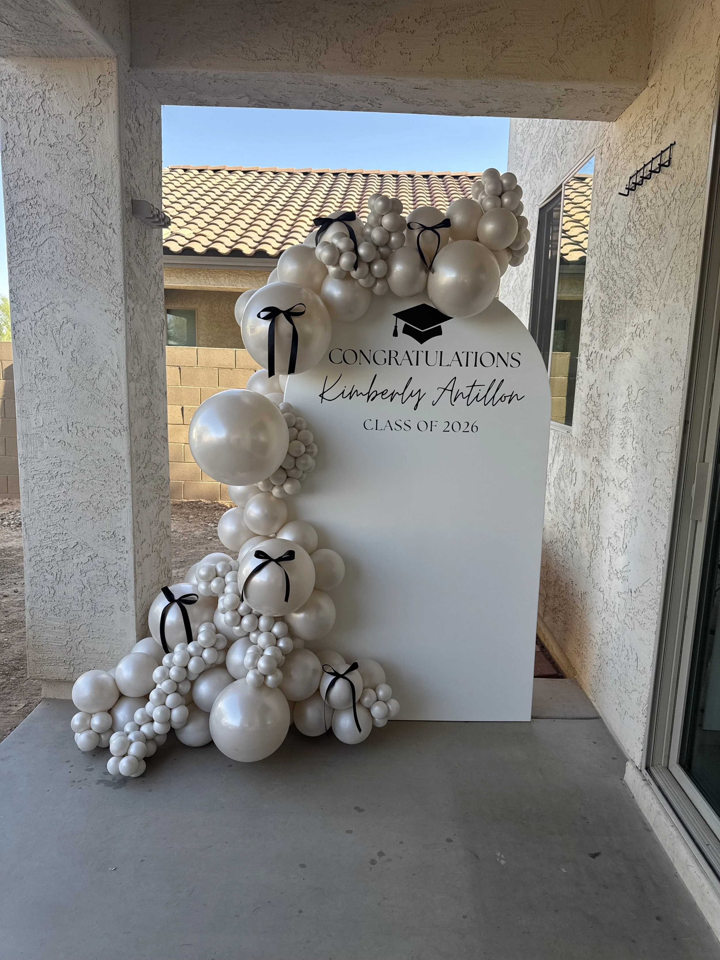 Ivory pearl balloons with black bow details for the Class of 2026 graduate