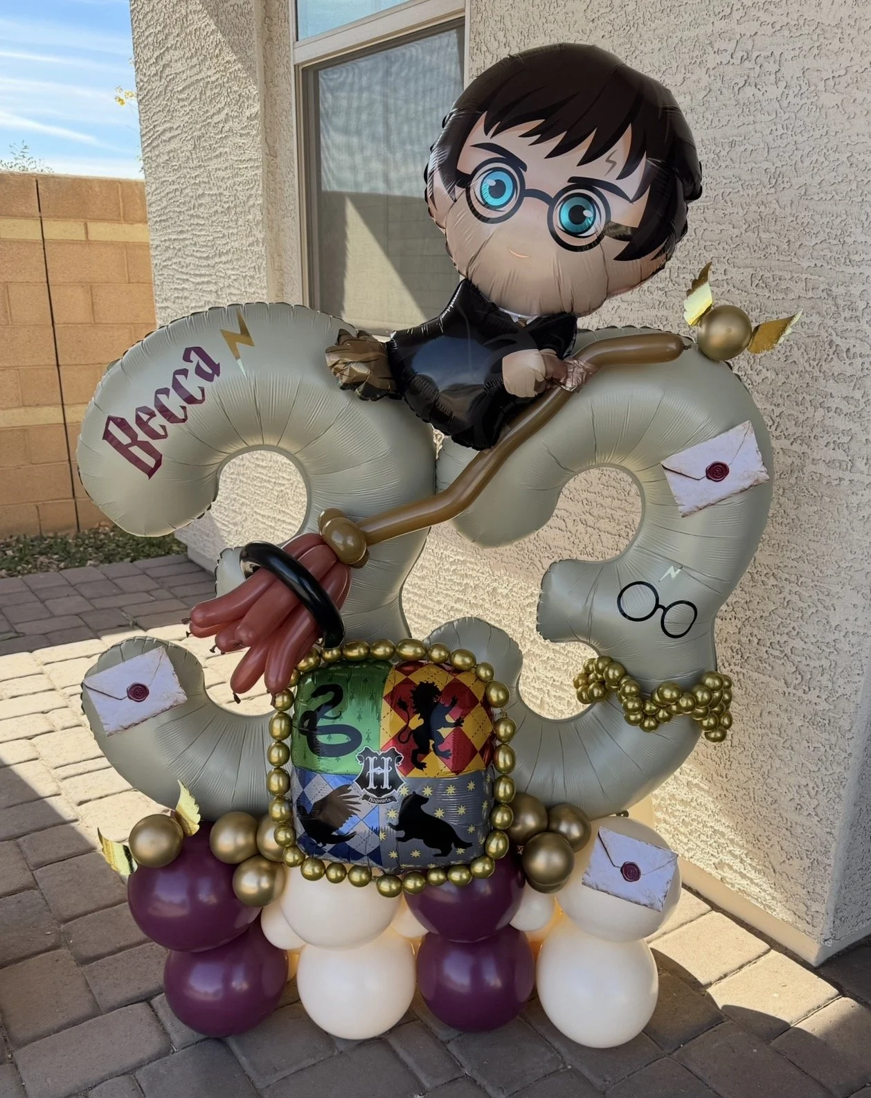 Harry Potter theme Balloon Stack featuring Harry Foil Balloon, custom balloon broom, letter & golden snitch details