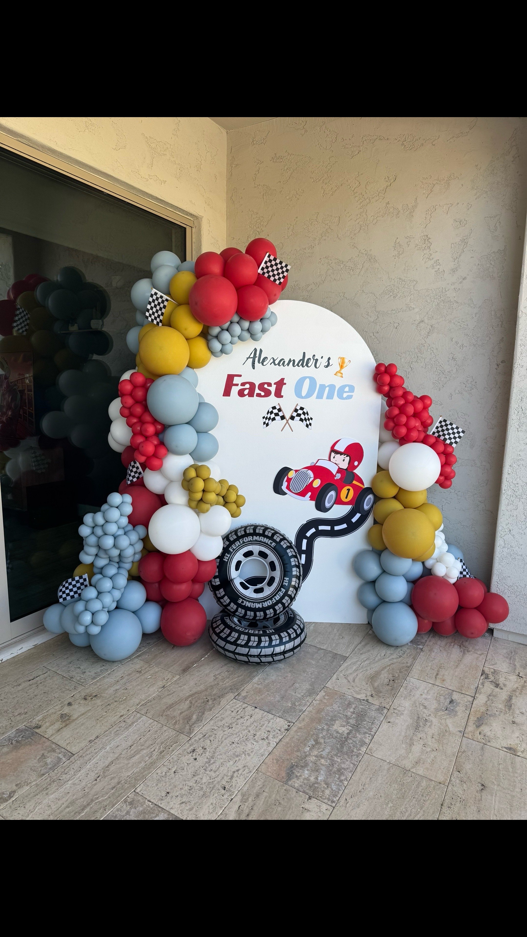 Fast One Birthday theme backdrop & balloons. Racecar, track, and tire props
