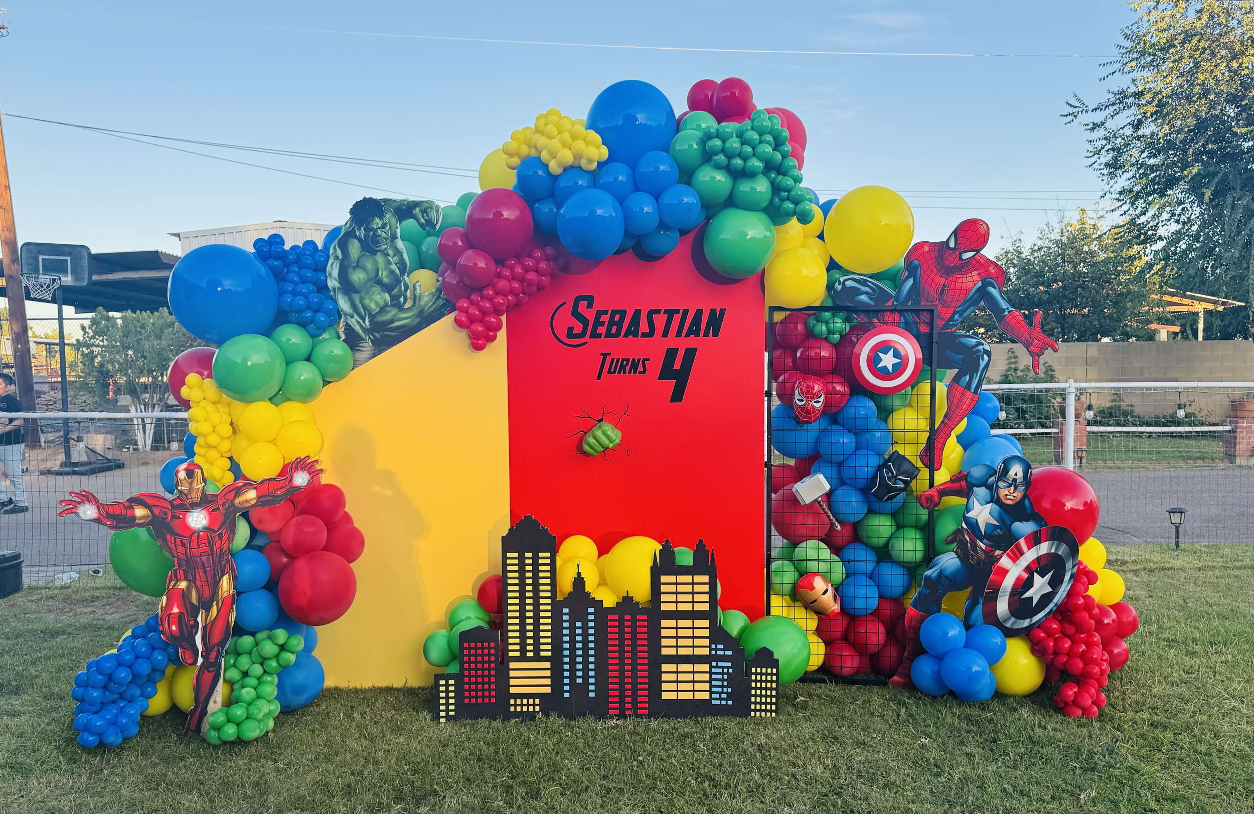 Marvel superhero-themed birthday party decoration featuring The Hulk, Spider-Man, Iron Man, Captain America, and Black Panther Includes 3D Hulk fist, light up Iron Man, and a cityscape silhouette.