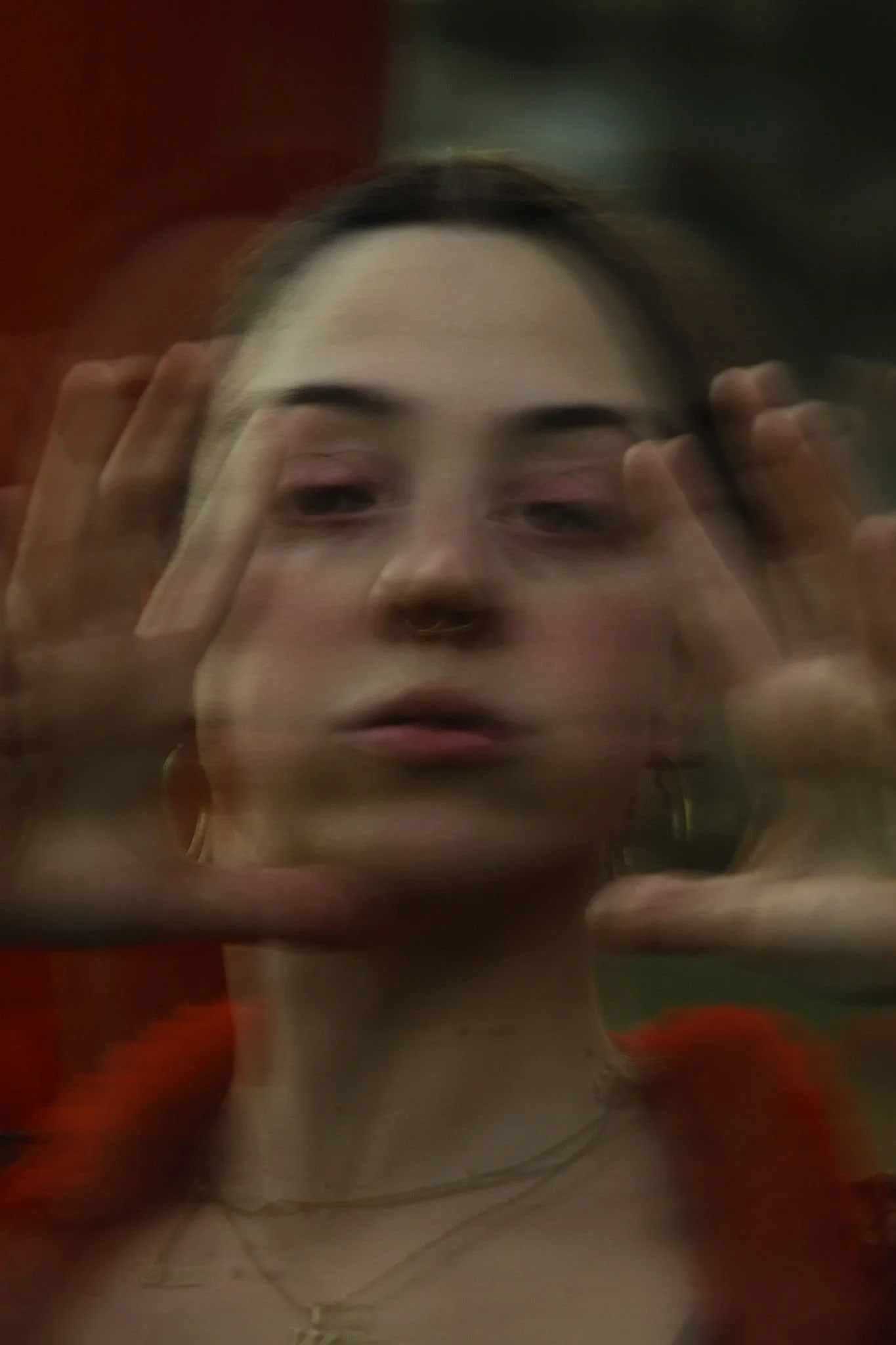 A woman posing creatively in a creative photoshoot, blurry and static to symbolise distortion and transition.