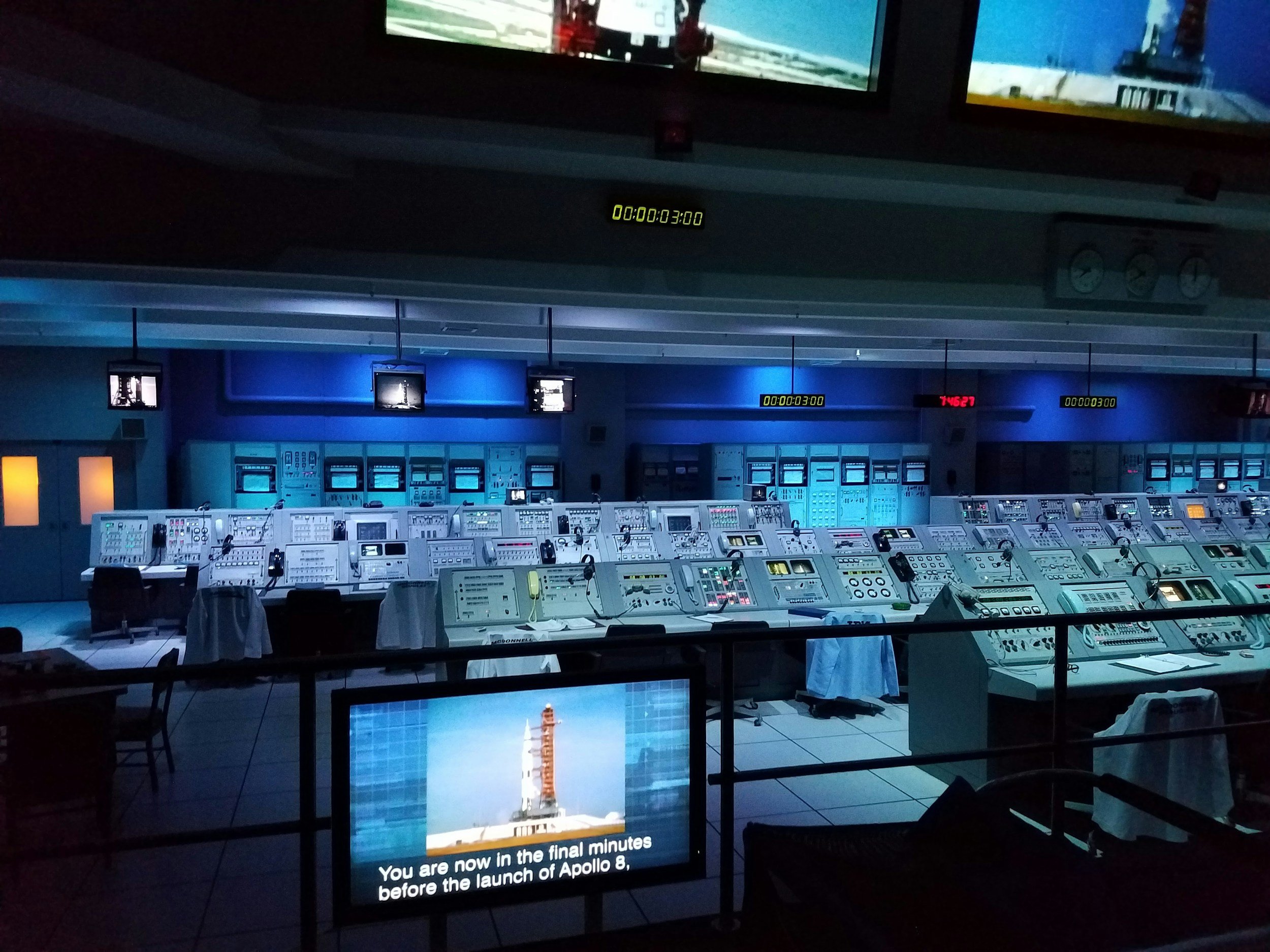 Control room lined with monitors showing system status, representing round-the-clock network and server monitoring