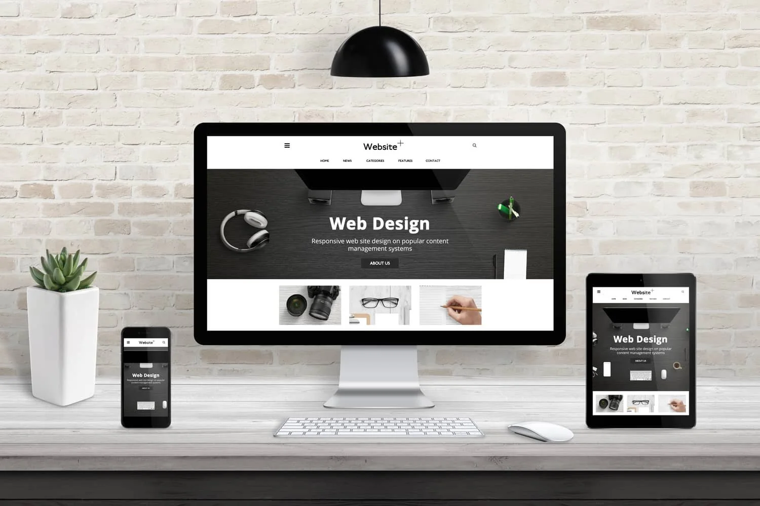 A modern workspace with a desktop computer, a smartphone, and a tablet, all displaying a web design homepage titled 'Web Design'. The desk is light wood, with a potted succulent on the left and a white keyboard and mouse in front of the computer, against a white brick wall.