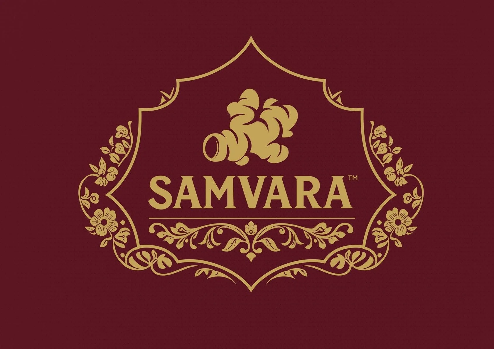 The image features a maroon background with a gold ornate frame. Inside the frame is a stylized gold graphic of a pipe with smoke. Below the graphic, the word 'SAMVARA' is written in gold capital letters, with a small trademark symbol next to it.