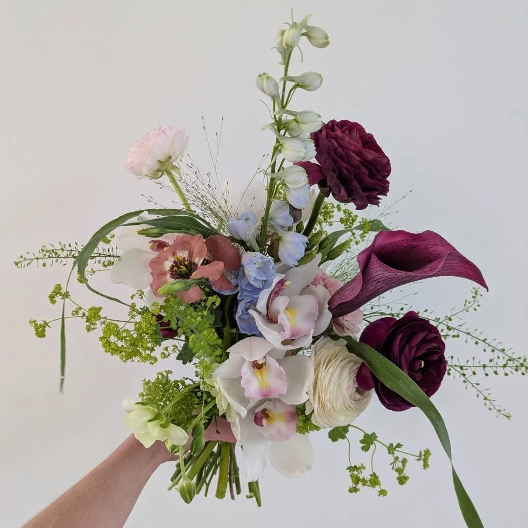 Not all bouquets have to be conventional.

While classic, structured bouquets will always have their place, I love exploring designs with movement, texture, and natural shape.

This arrangement combines soft orchids, ranunculus, calla lilies, delphin
