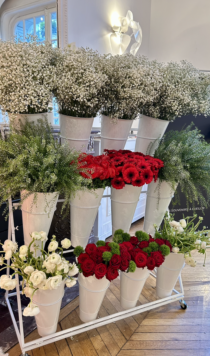 Vases blancs avec fleurs blanches, rouges et vertes, decorés pour une exposition florale