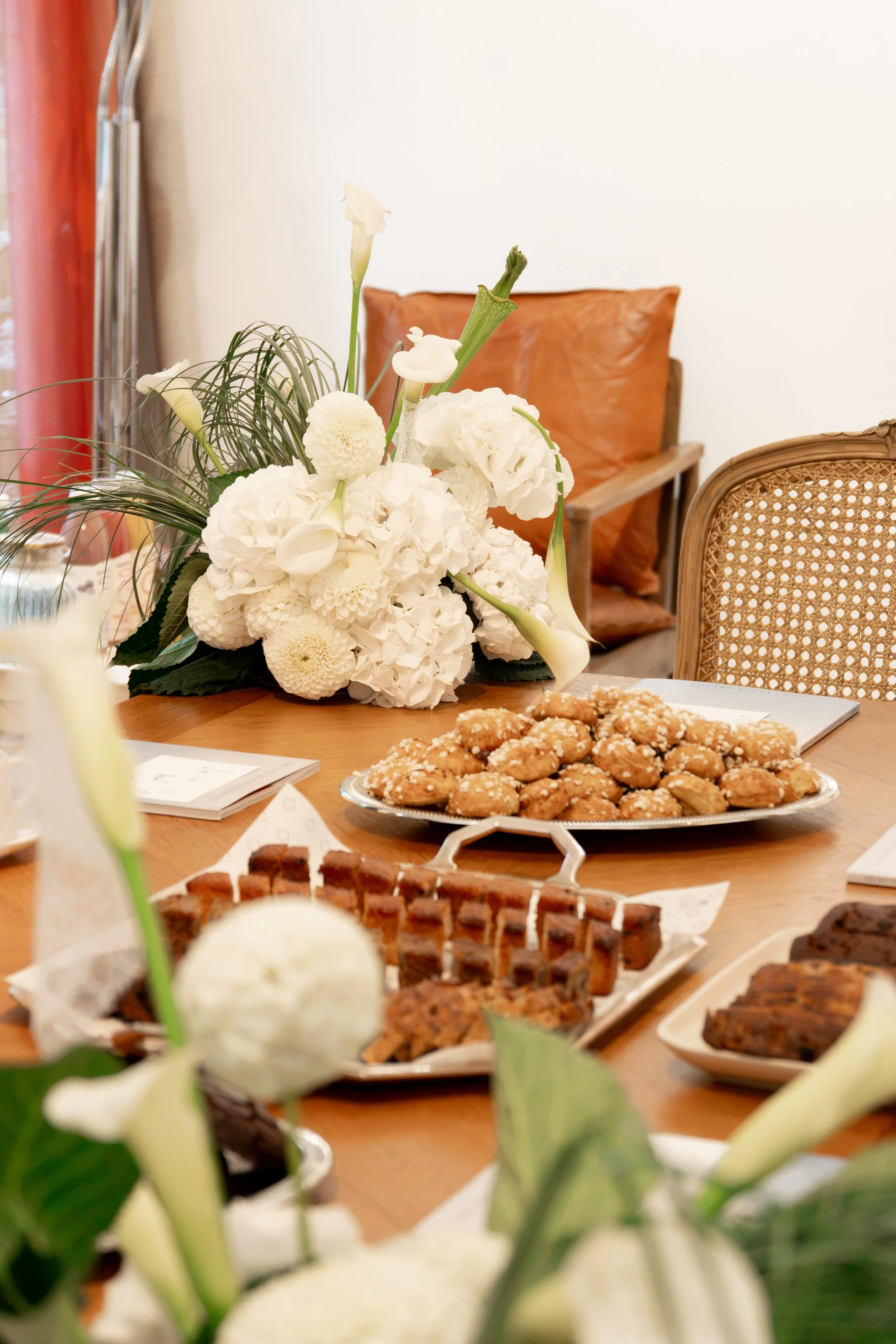 Un buffet avec des fleurs blanches, des cupcakes, et des desserts, dans une salle de réception. 
