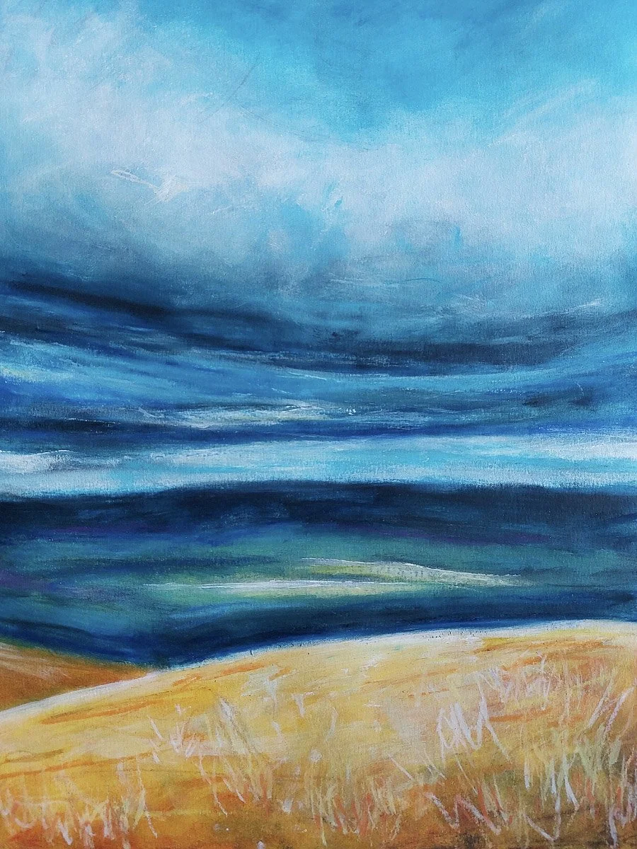 Abstract landscape painting of a sandy beach, ocean, and sky with clouds in shades of blue and yellow.