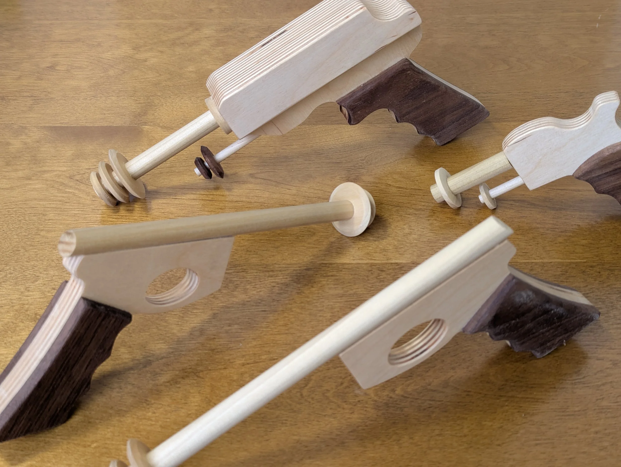 Various wooden toy train tracks and pieces laid out on a wooden surface.