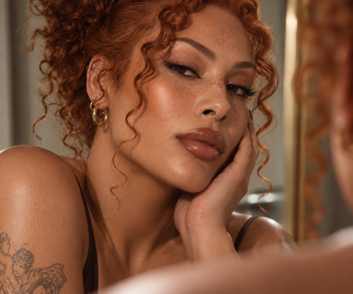 Close-up portrait of a light-skinned mixed-race person with curly red hair and freckles.