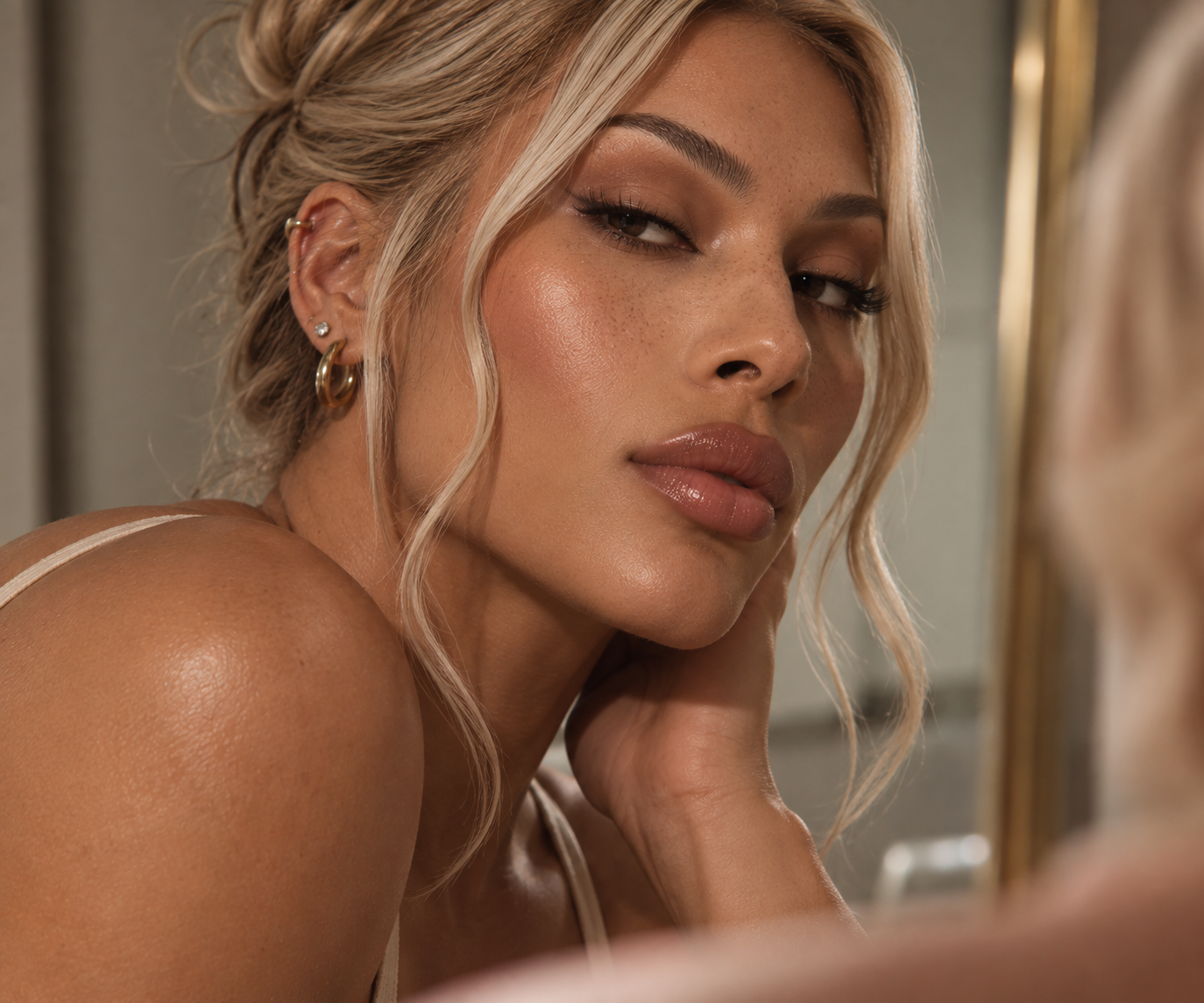 Close-up portrait of a blonde feminine-presenting person with defined features and glowing skin.