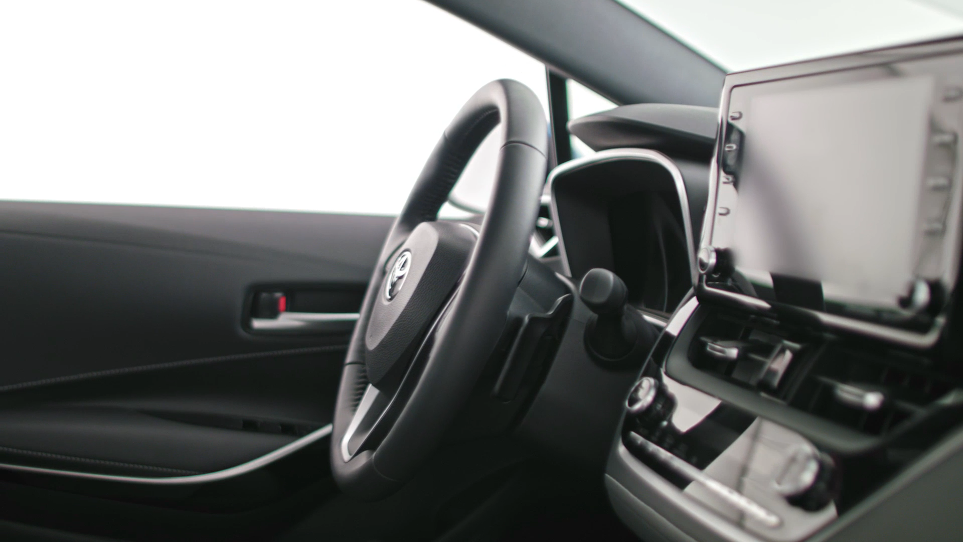 Interior of a car showing the steering wheel, dashboard, and a touchscreen display.
