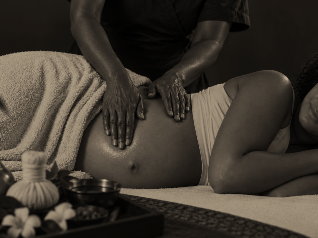Persoon krijgt een massage op de buik van een therapeut in een wellnessruimte.