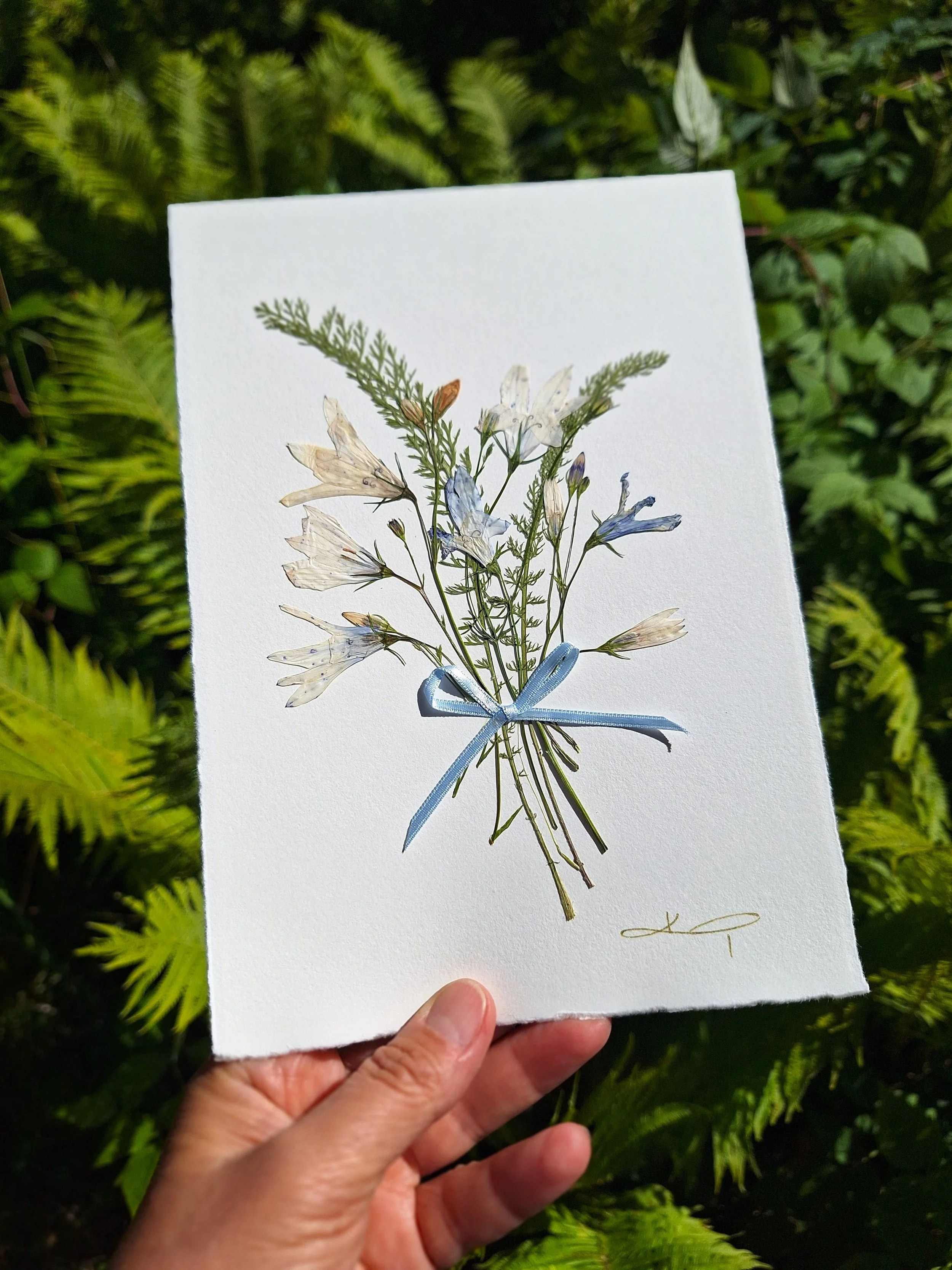 An A5 double-fold unique greeting card handcrafted with care using authentic, hand-sourced pressed bellflowers.
