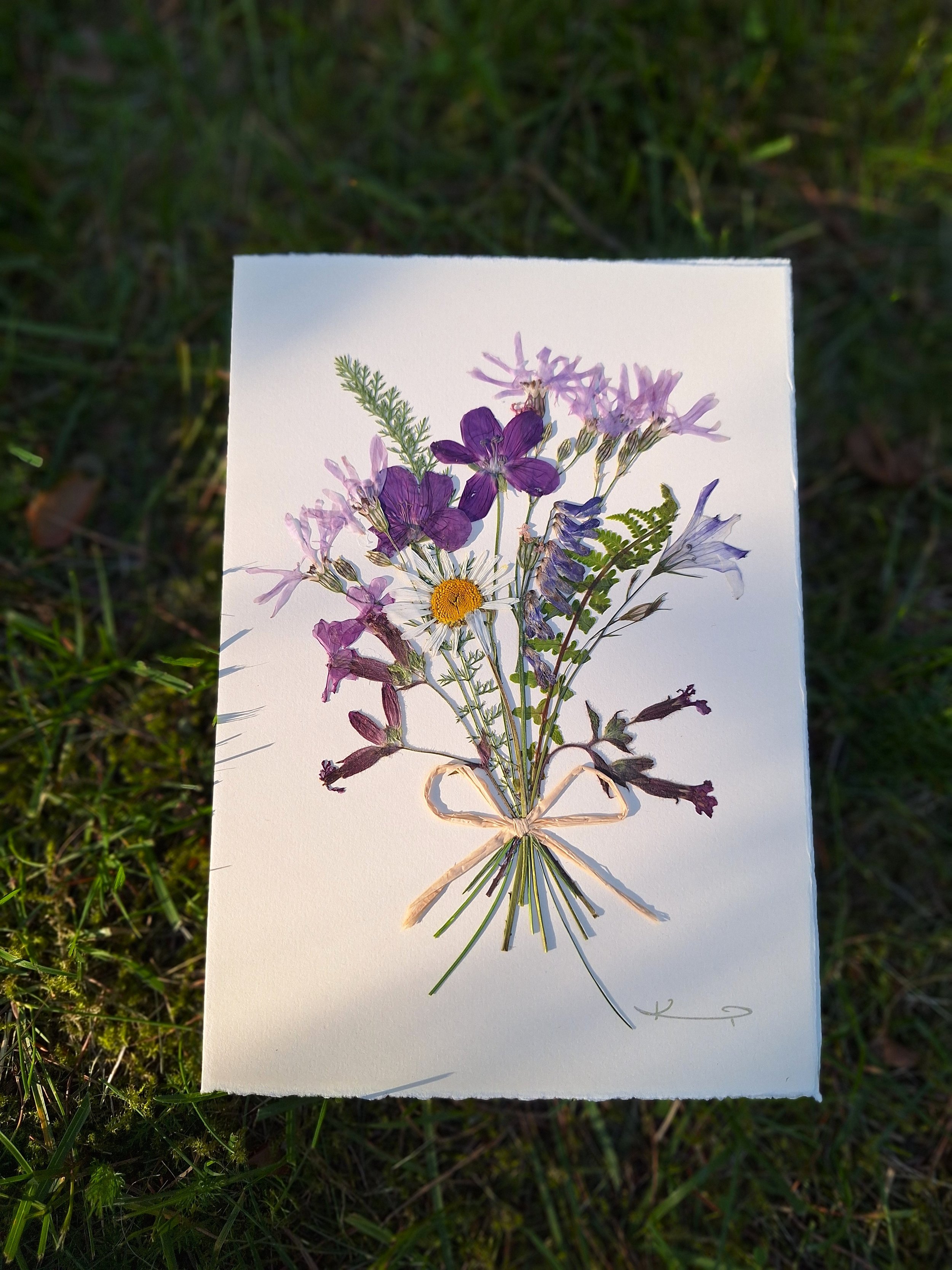 A pressed flower greeting card with joyful wildflowers bouquet