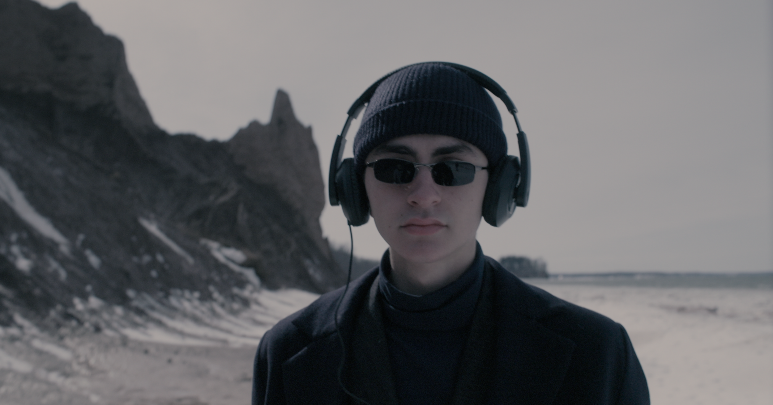 man with metal detector headset on walking at Chimney Bluffs State Park