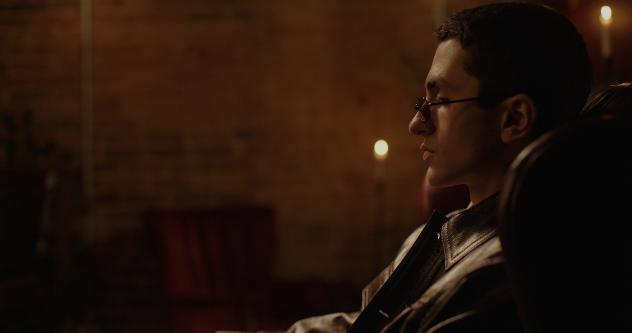 side profile of man at coffee shop in dark cinematic lighing