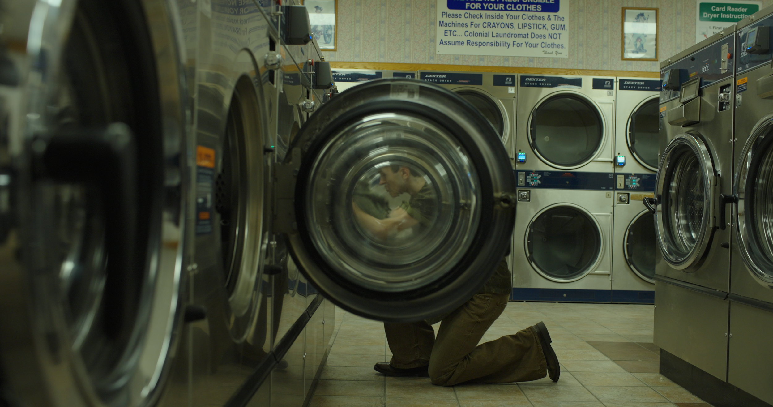 man putting laundry in machine through machine doors