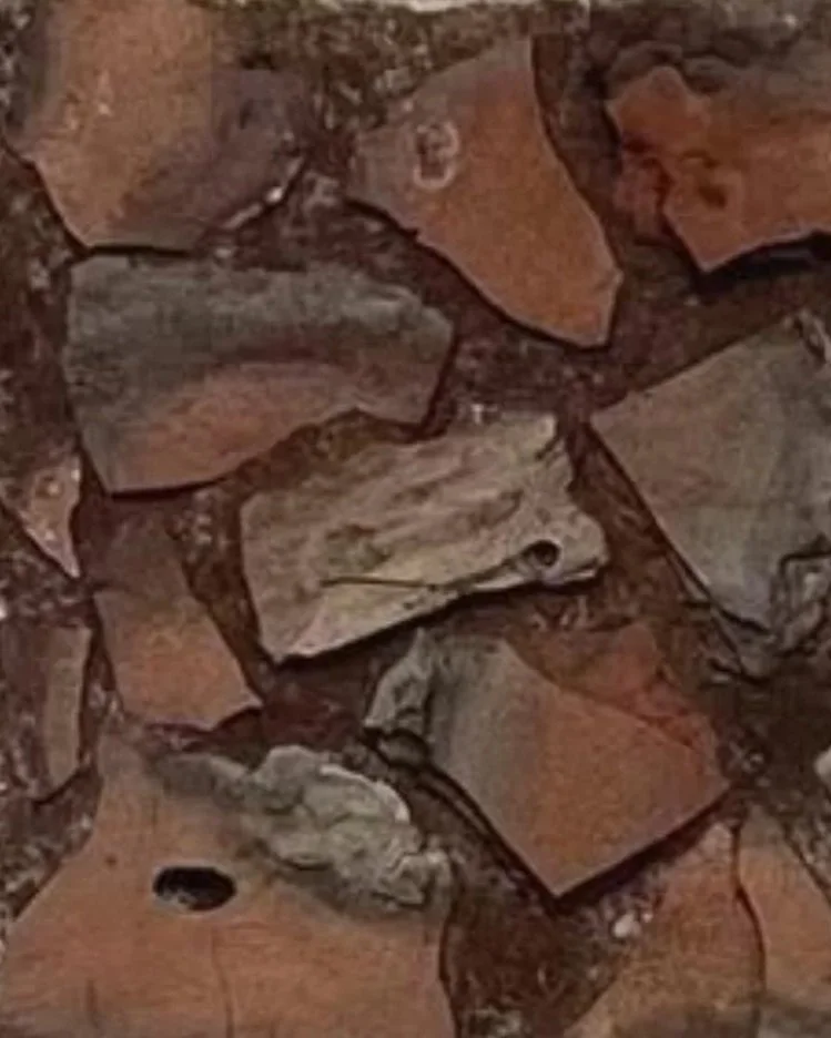 Close-up of a pile of irregularly shaped, reddish-brown stones or clay materials.