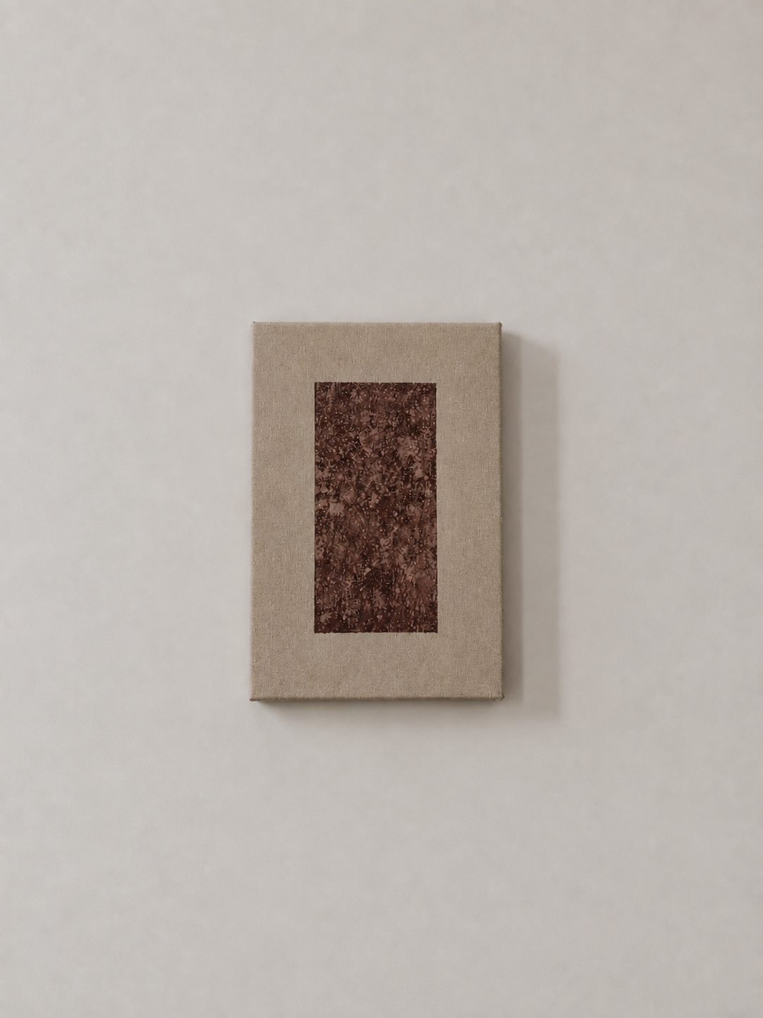 A small rectangular box with a brown and red marbled pattern on the top, set against a plain light-colored background.