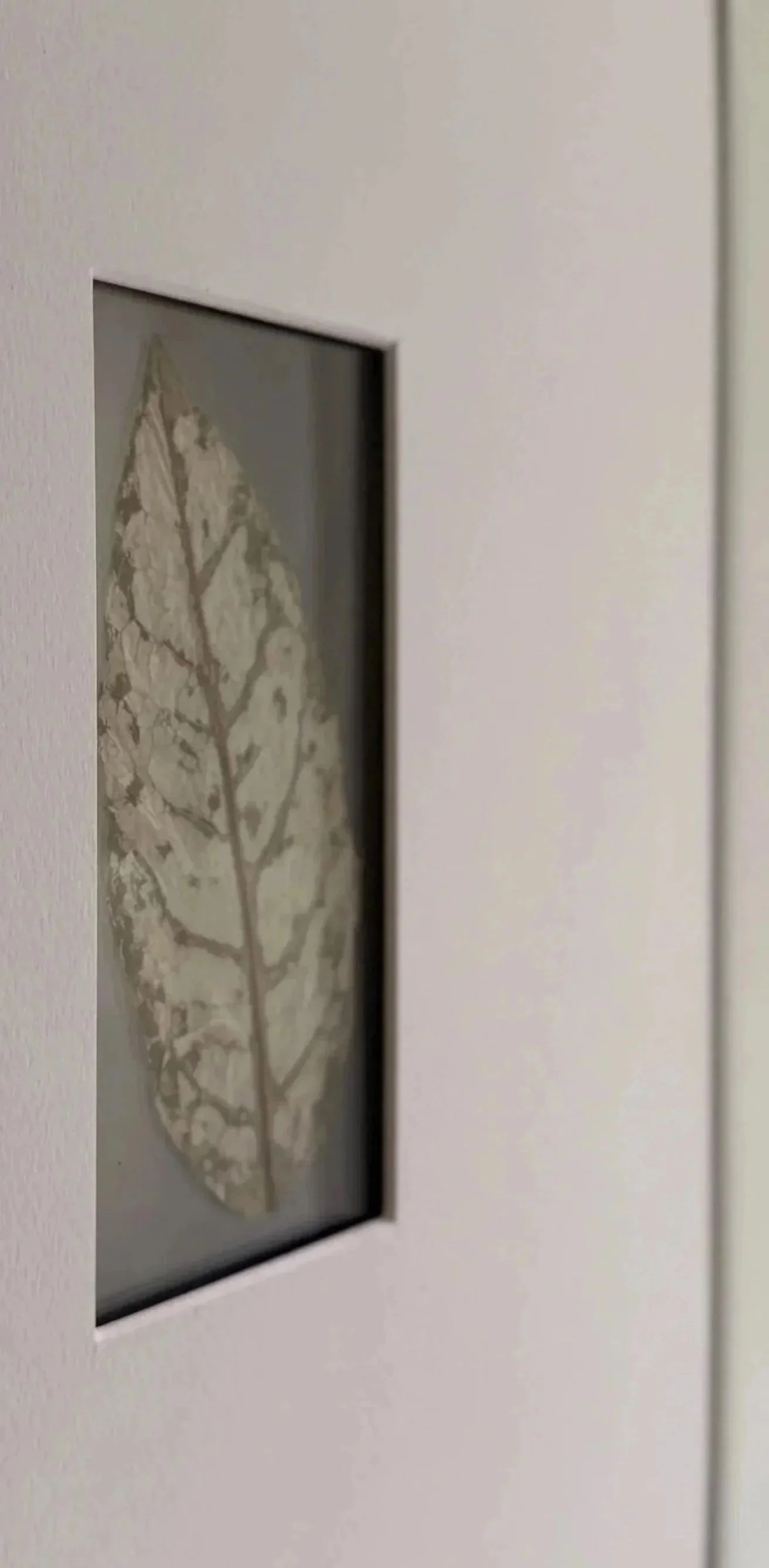 Close-up of a digital thermostat on a white wall, displaying a leaf graphic.
