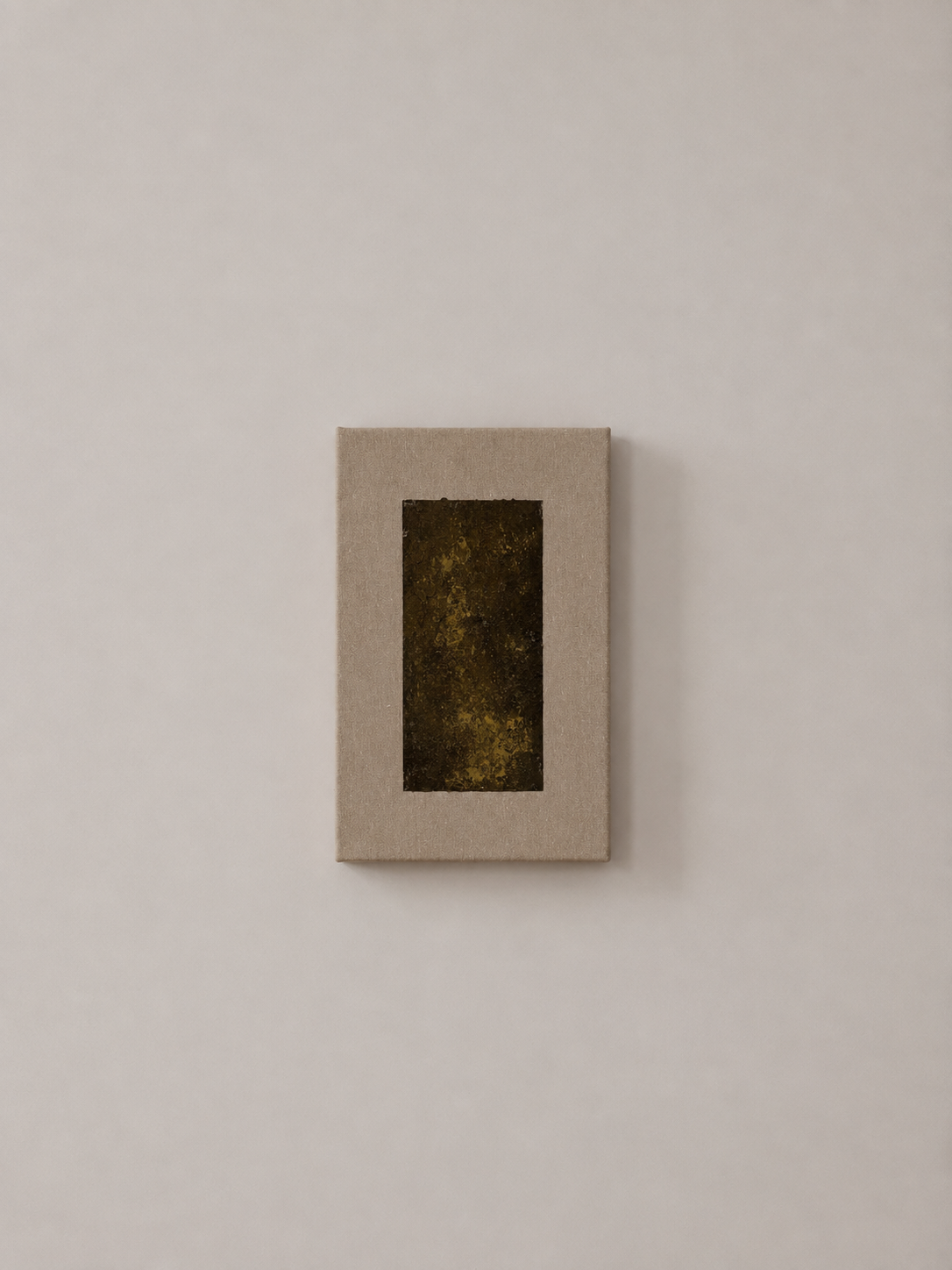 A framed piece of abstract art with dark earthy tones, displayed on a plain white wall.