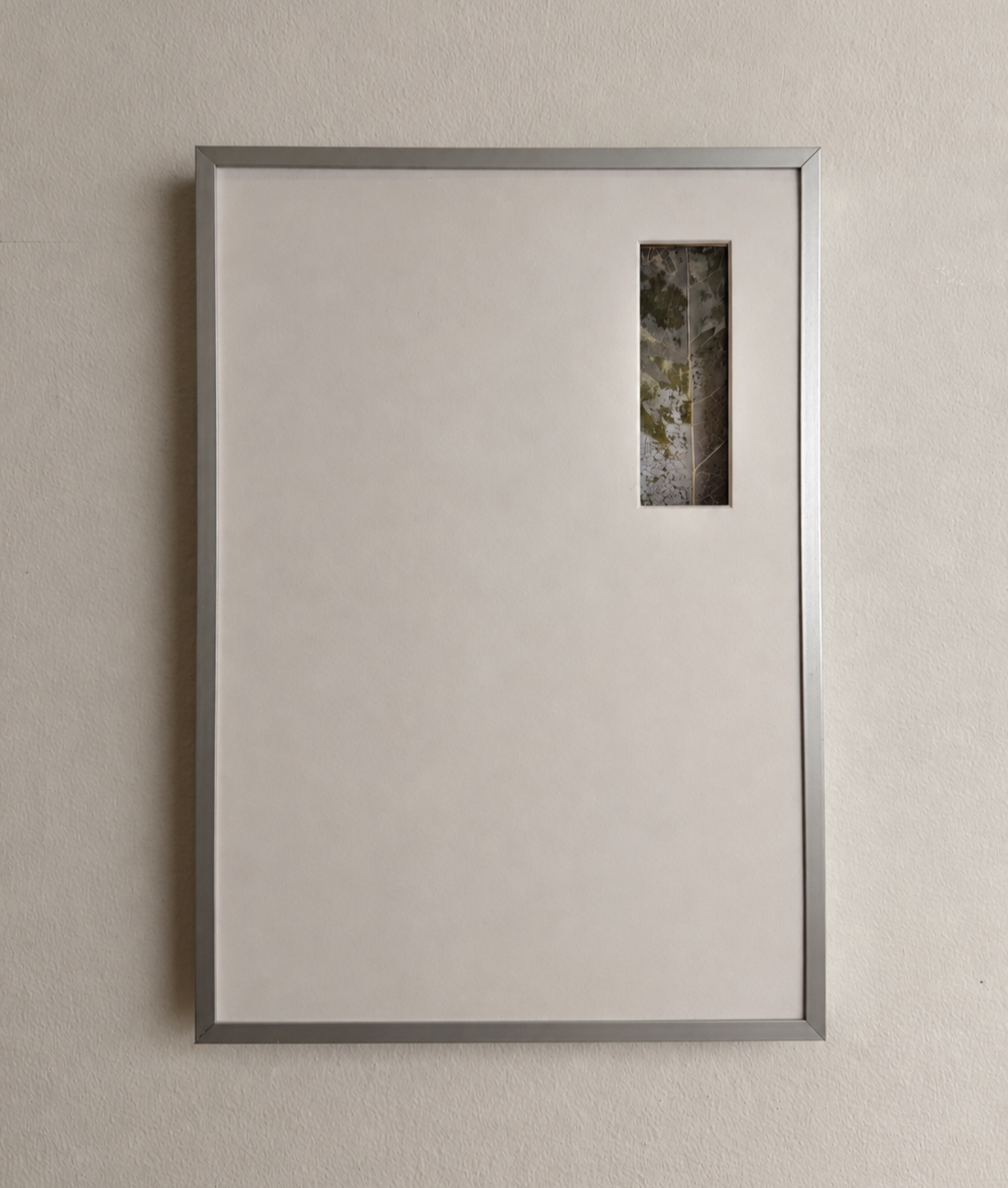 A framed white board with a small rectangular window showing a view of trees.
