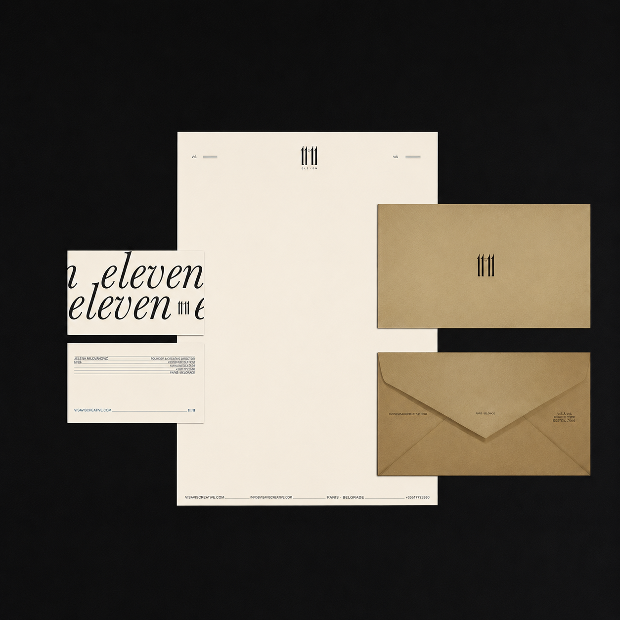 A collection of branding and stationery items including a white certificate, a card with 'eleven' written repeatedly, a brown envelope, and a beige folder with Roman numeral '111' on the cover, all arranged on a black background.