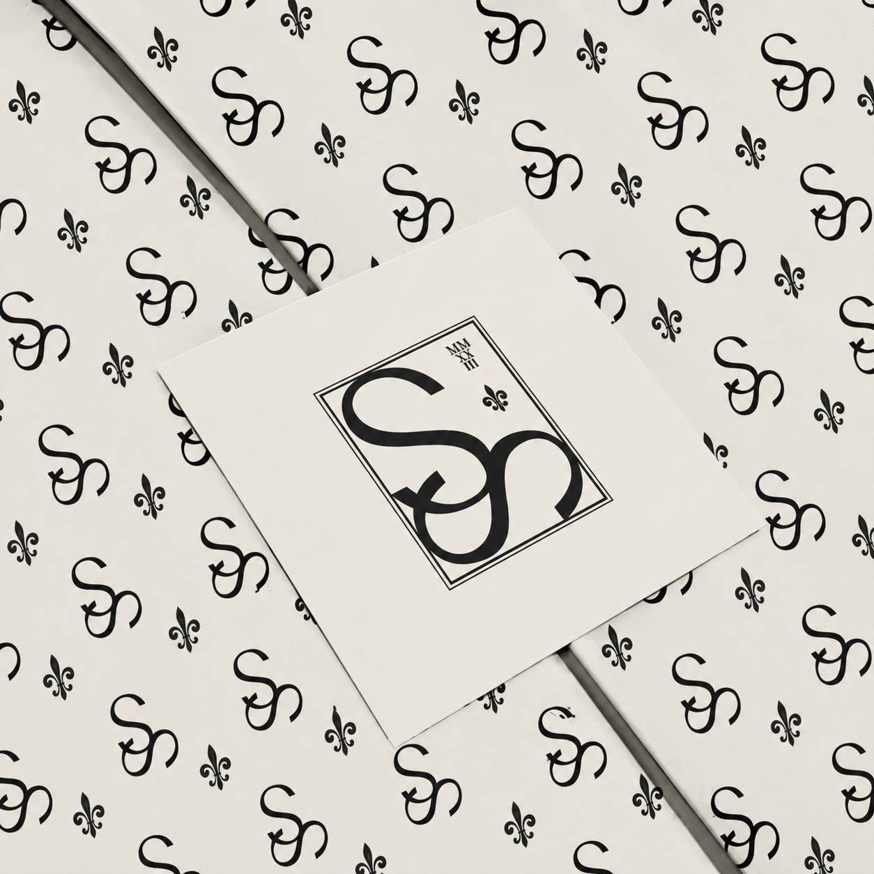 Decorative paper with black and white Star Studios logo, featuring intertwined 'S' and fleur-de-lis symbols.