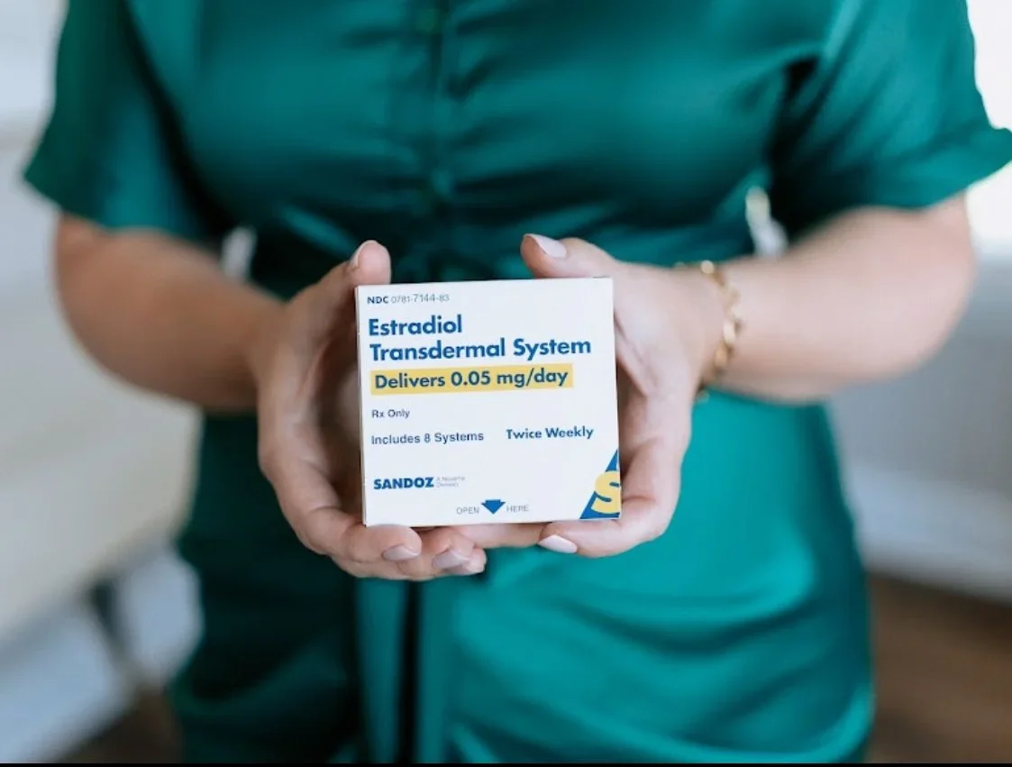 Person holding a box of Estradiol Transdermal System medication.