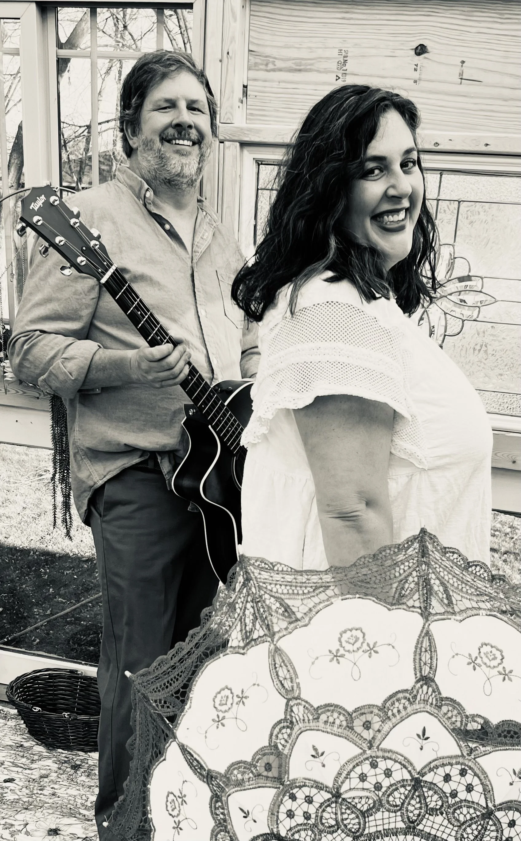 Aaron Lipp and Caroline Lipp of The Wandering Tulipps smiling together with an acoustic guitar, reflecting the warmth and harmony of their Indiana folk and Americana music.