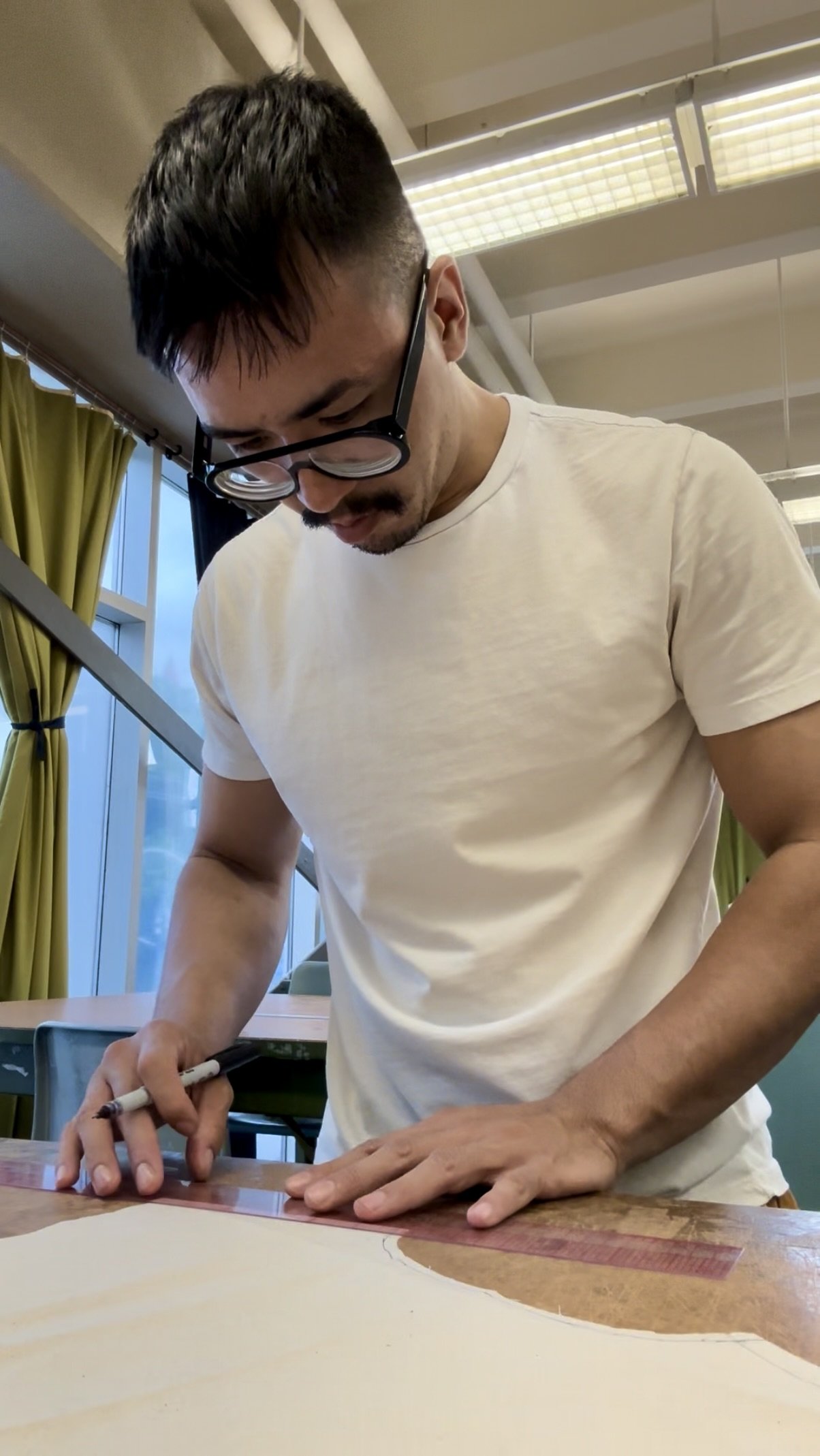 Carlos working on a piece of fabric in studio.