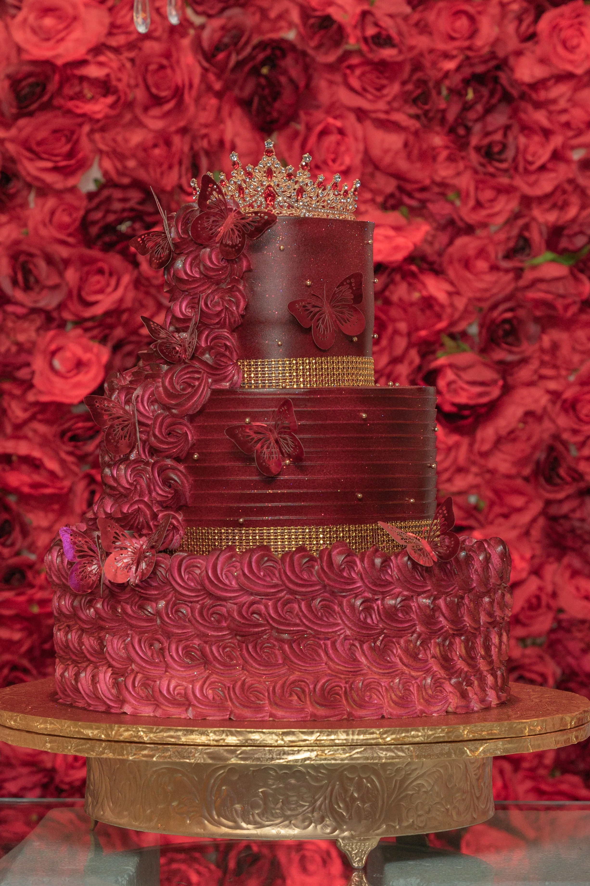 A red cake with red roses in the background