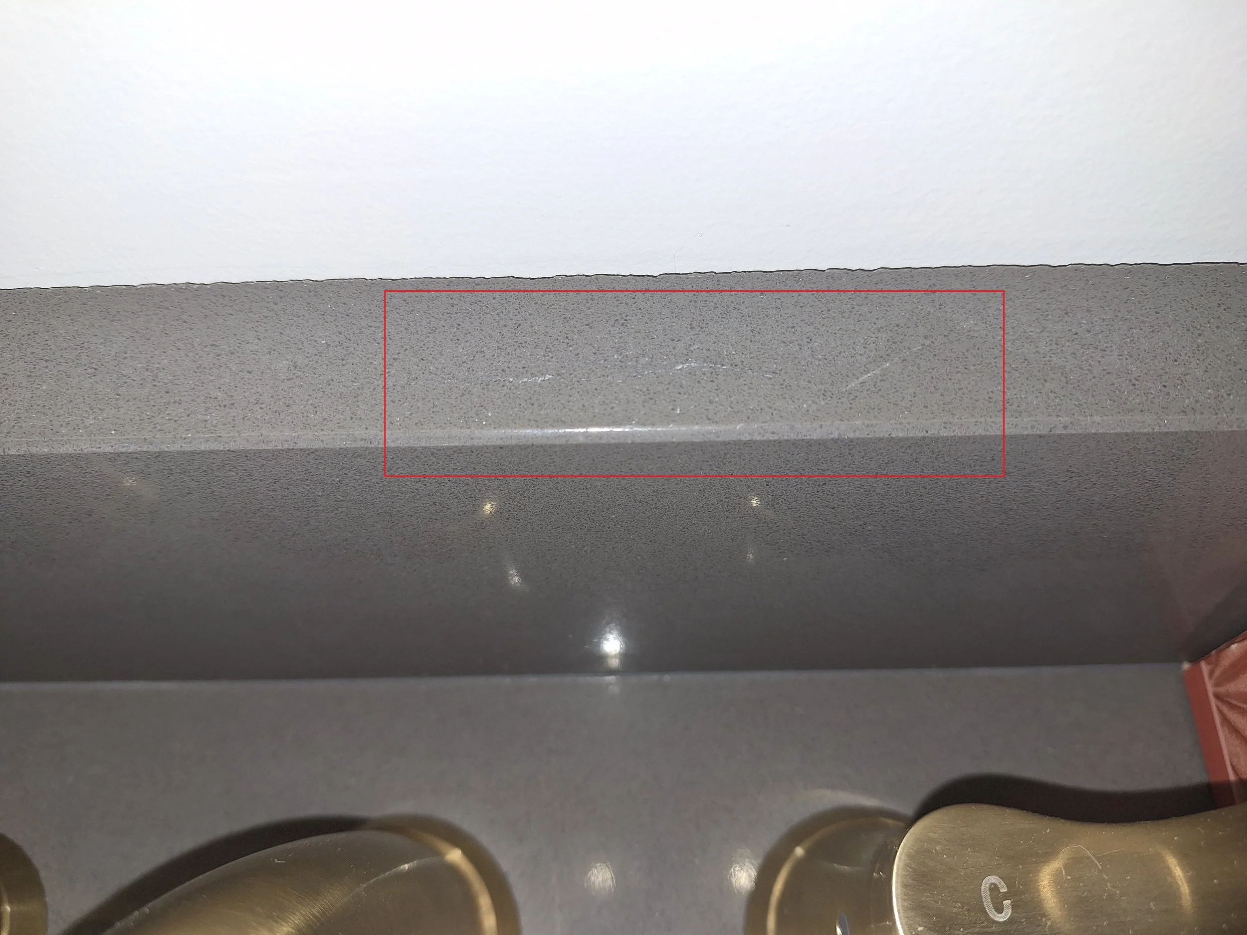View of an elevator control panel with multiple round metallic buttons and a red outline around a section
