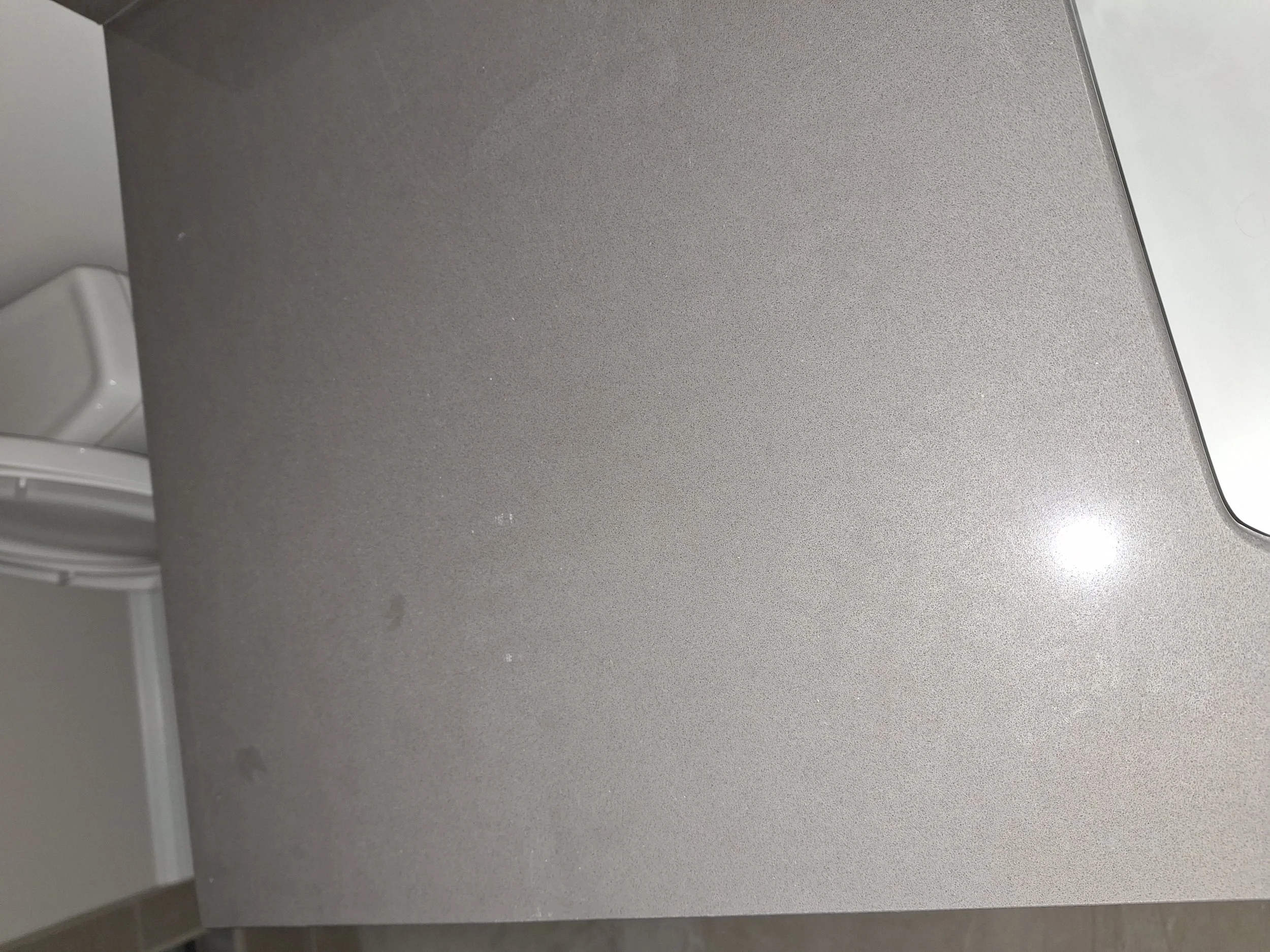 Close-up of a metallic gray surface, possibly part of an electronic device or appliance.