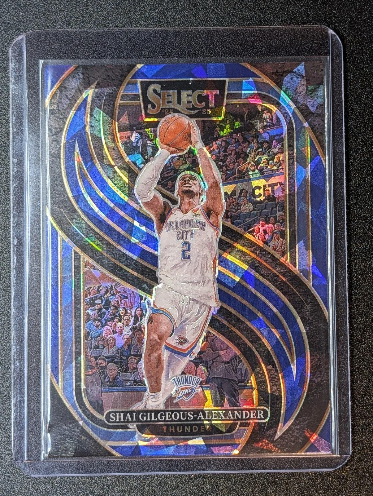 Front of 2024-25 Panini Select #131 Shai Gilgeous-Alexander Blue Cracked Ice Prizm