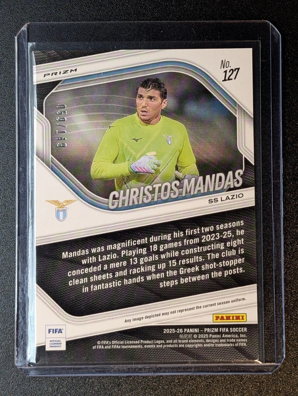 Back of 2025-26 Panini Prizm FIFA #127 Christos Mandas Red Prizms #/149