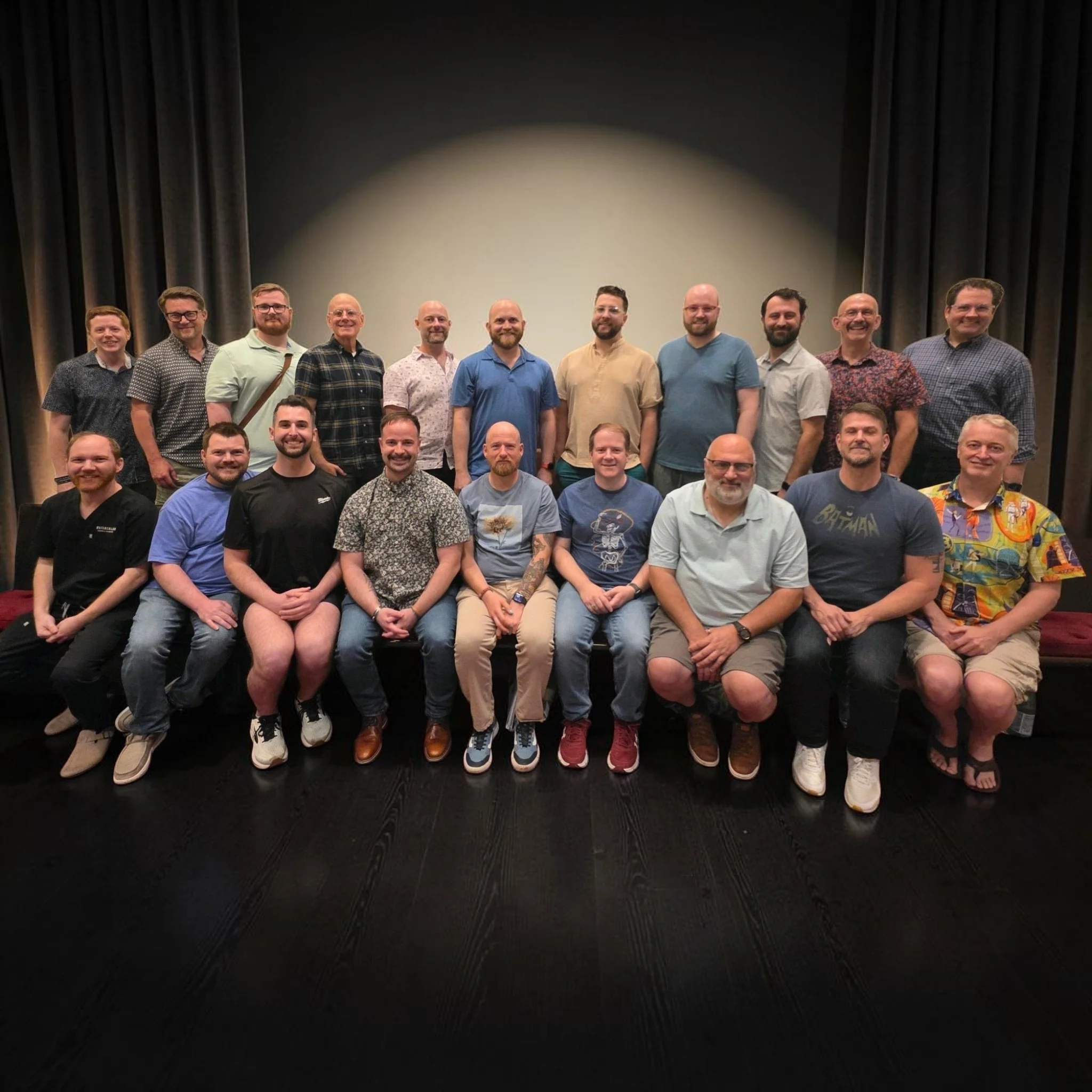 Group of people standing together on stage after a presentation or event, with some smiling and looking at the camera.