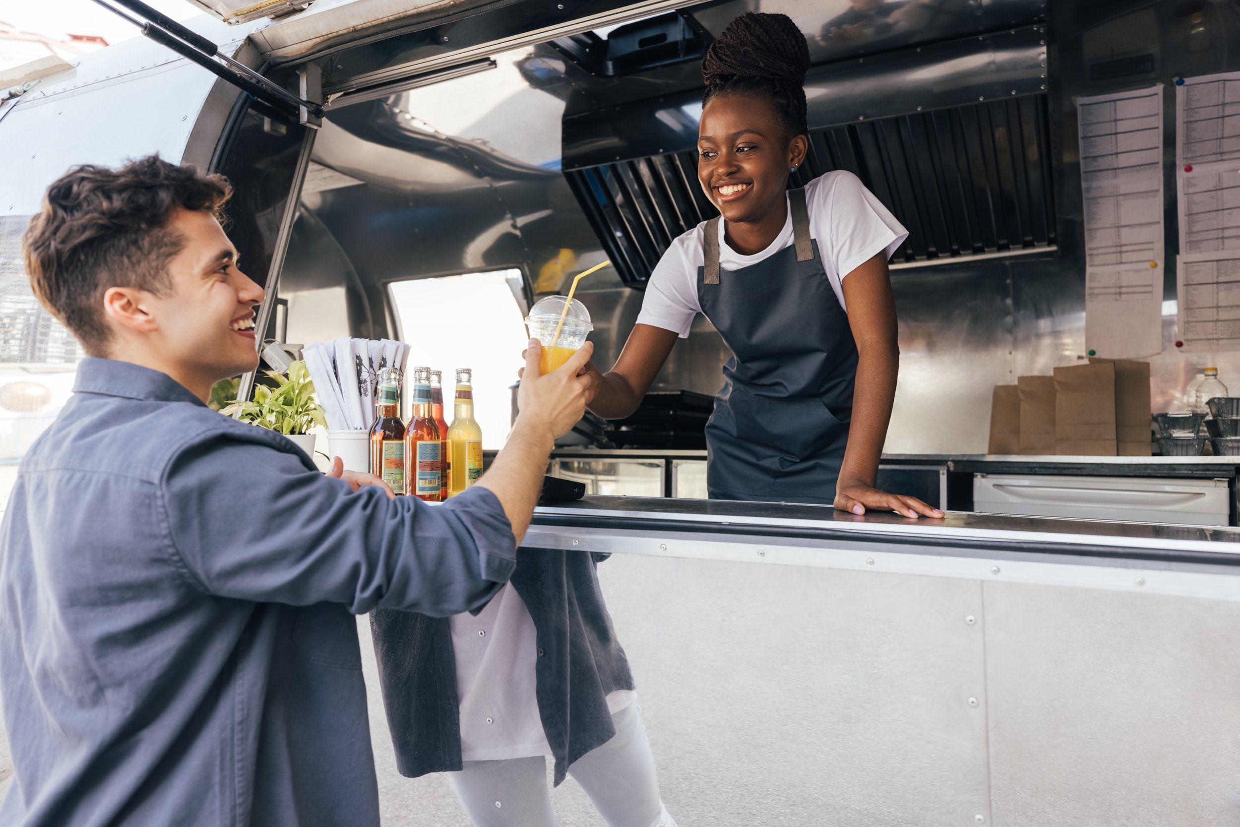 smiling-food-truck-worker-handing-drink-to-custome-2026-03-19-09-27-05-utc.jpeg